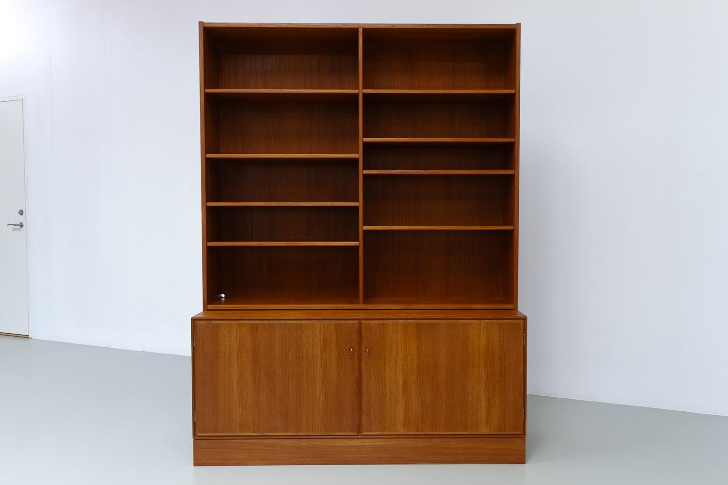 Danish Modern Teak Bookcase, 1960s.
Danish Mid-Century Modern bookcase and cabinet in teak. Manufactured in Denmark in the 1960s. In the style of Carlo Jensen/Hundevad/Børge Mogensen.

This bookcase consists of two parts. Upper part with eight