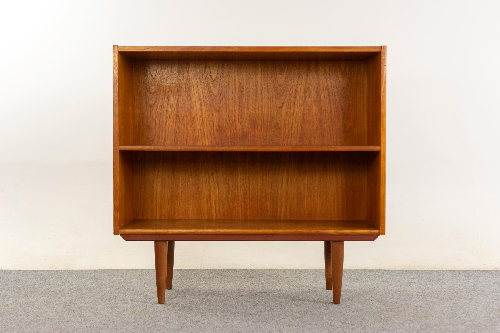 Teak Danish bookcase, circa 1960's. Teak veneered case with adjustable shelf and sleek tapered legs.

Unrestored item with the option to purchase in restored condition for an additional $200 USD. Restoration includes: repairs, sanding, staining, and