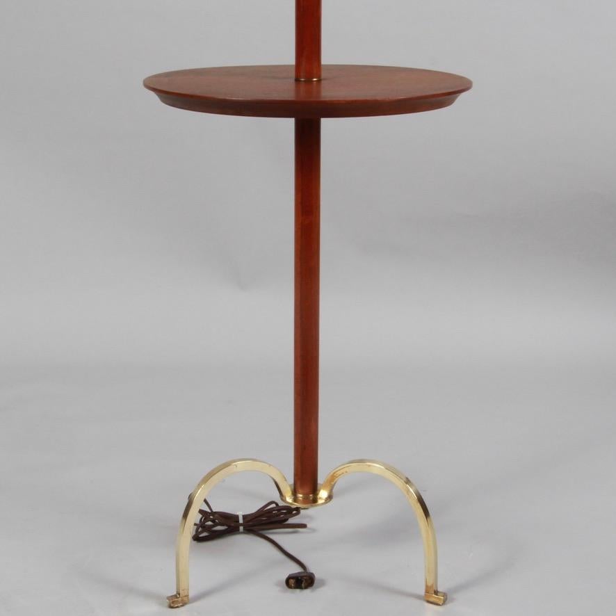 Pristine mid century teak floor lamp with table and solid brass tripod feet. Wiring may be original, but works perfectly. Can take two 100 watt bulbs. Shipped without lampshade.