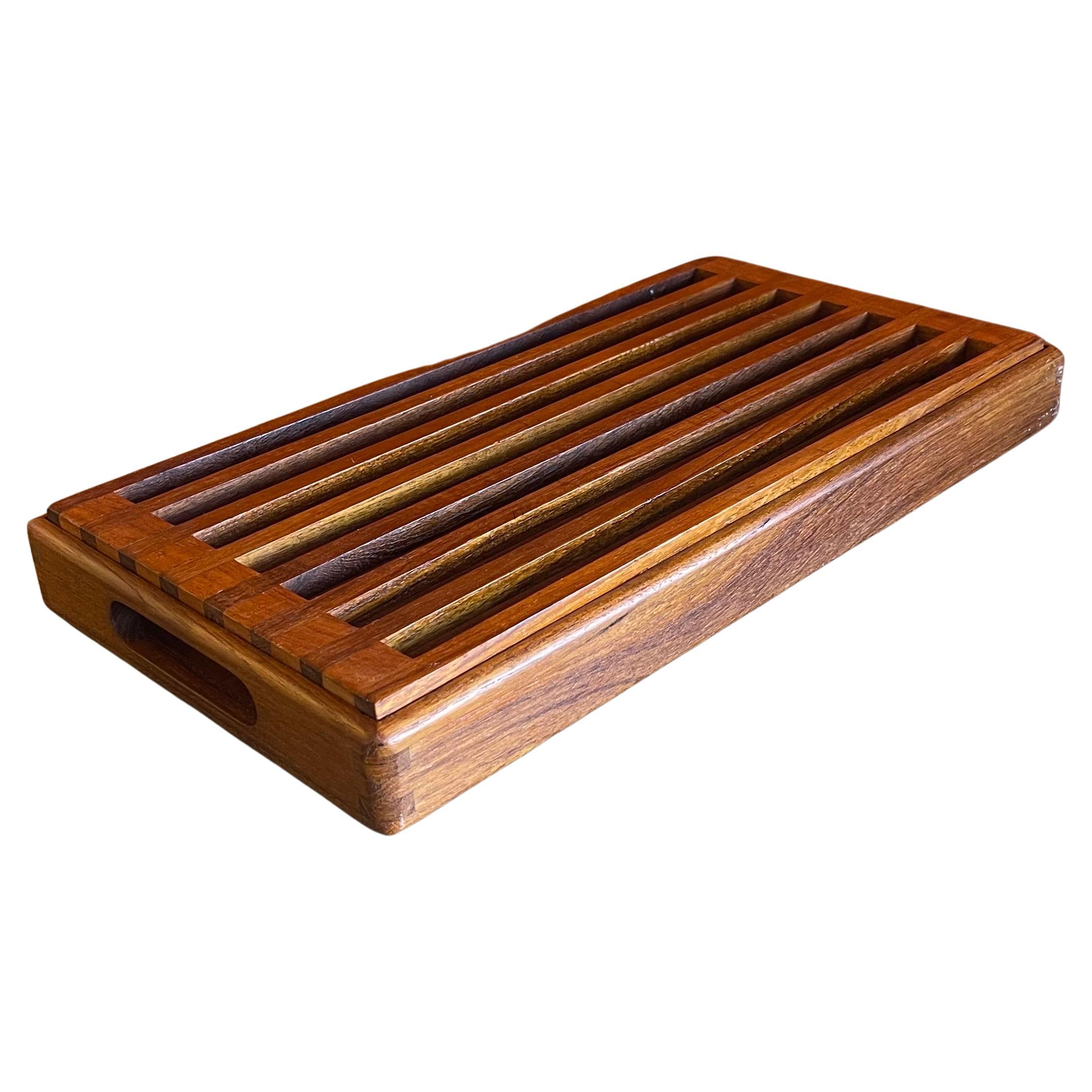 A very nice Danish modern teak bread cutting board with handles, circa 1970s. The board is in good vintage condition and measures 15.5