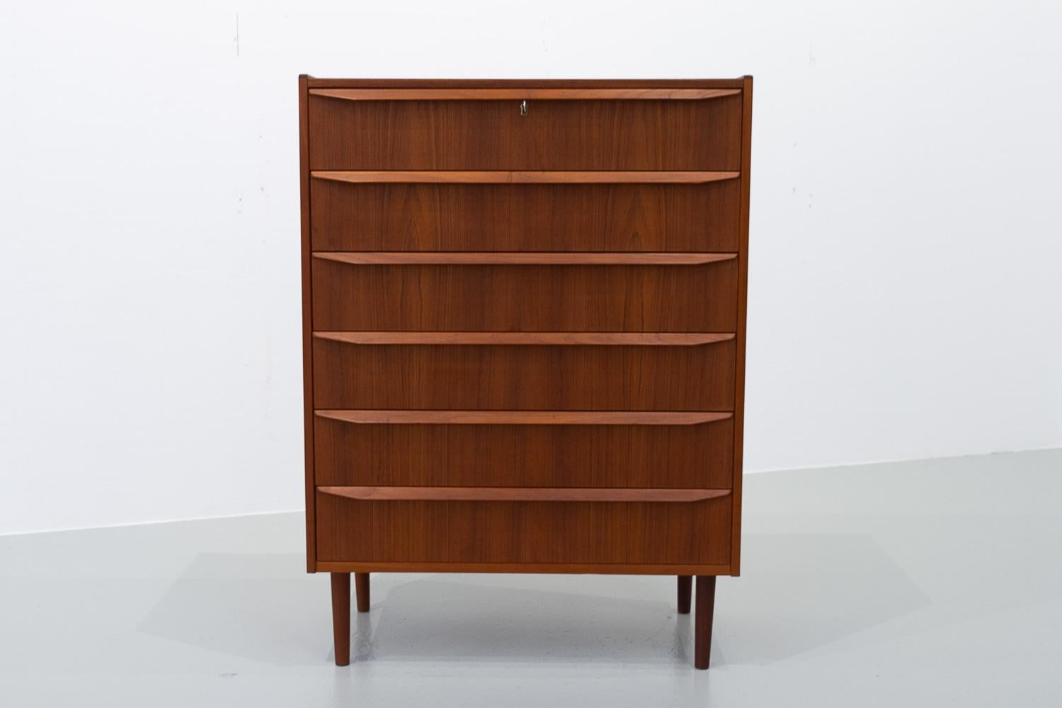 Danish Modern Teak Chest of Drawers, 1960s.

Mid-century modern six drawer dresser in teak made in Denmark in the 1960s.

Beautiful matched veneer patterns on drawer fronts. Round tapered legs in solid teak. Wide drawer pulls in solid teak with