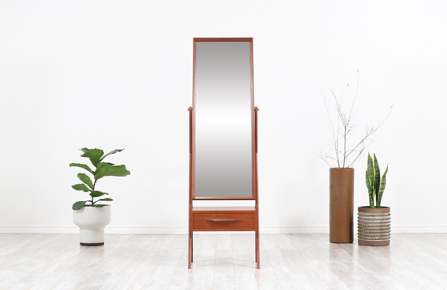 Classy Danish modern cheval dressing mirror designed and manufactured in Denmark, circa 1950s. This versatile dressing mirror features a solid teak construction with its original swivel mirror and an exquisite warm grain detail throughout the
