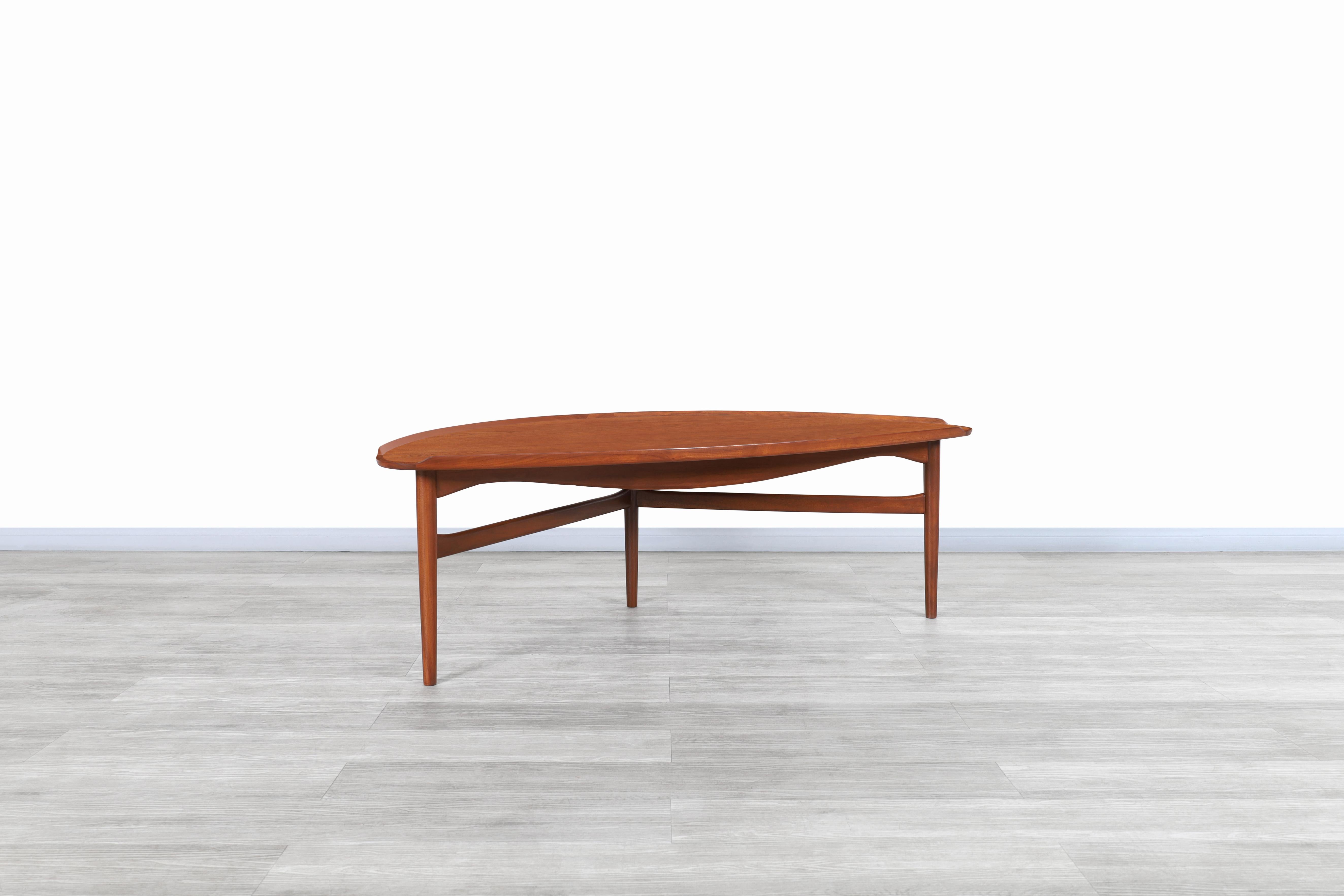 Exceptional Danish modern teak cocktail table designed by iconic designer Finn Juhl for Baker Furniture in the United States, circa 1950s. This cocktail table has a sculptural design with no sharp corners that allow you to move freely around it. It