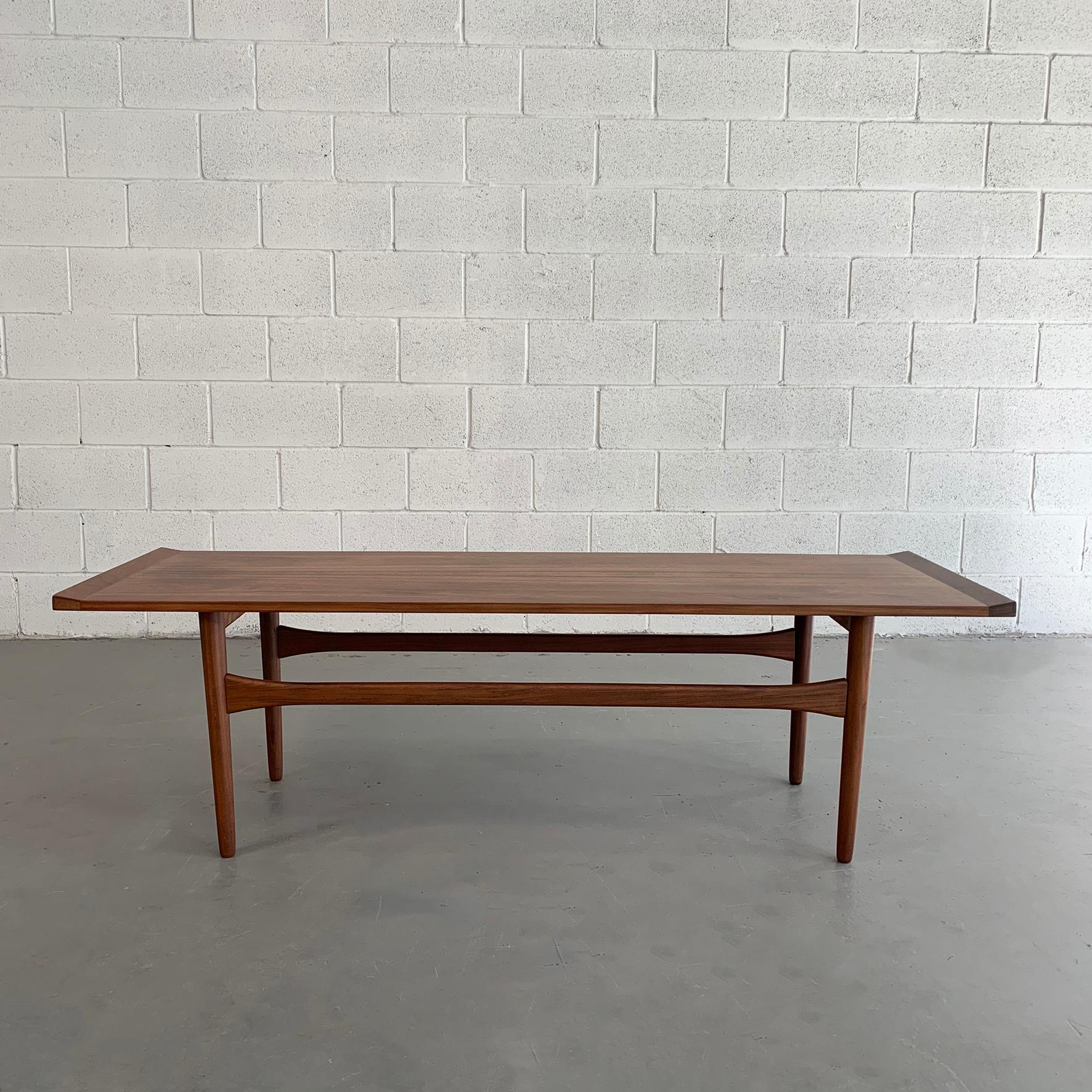 Minimal and elegant, Danish modern, long, teak, rectangular coffee table featuring upturned edges is newly finished.