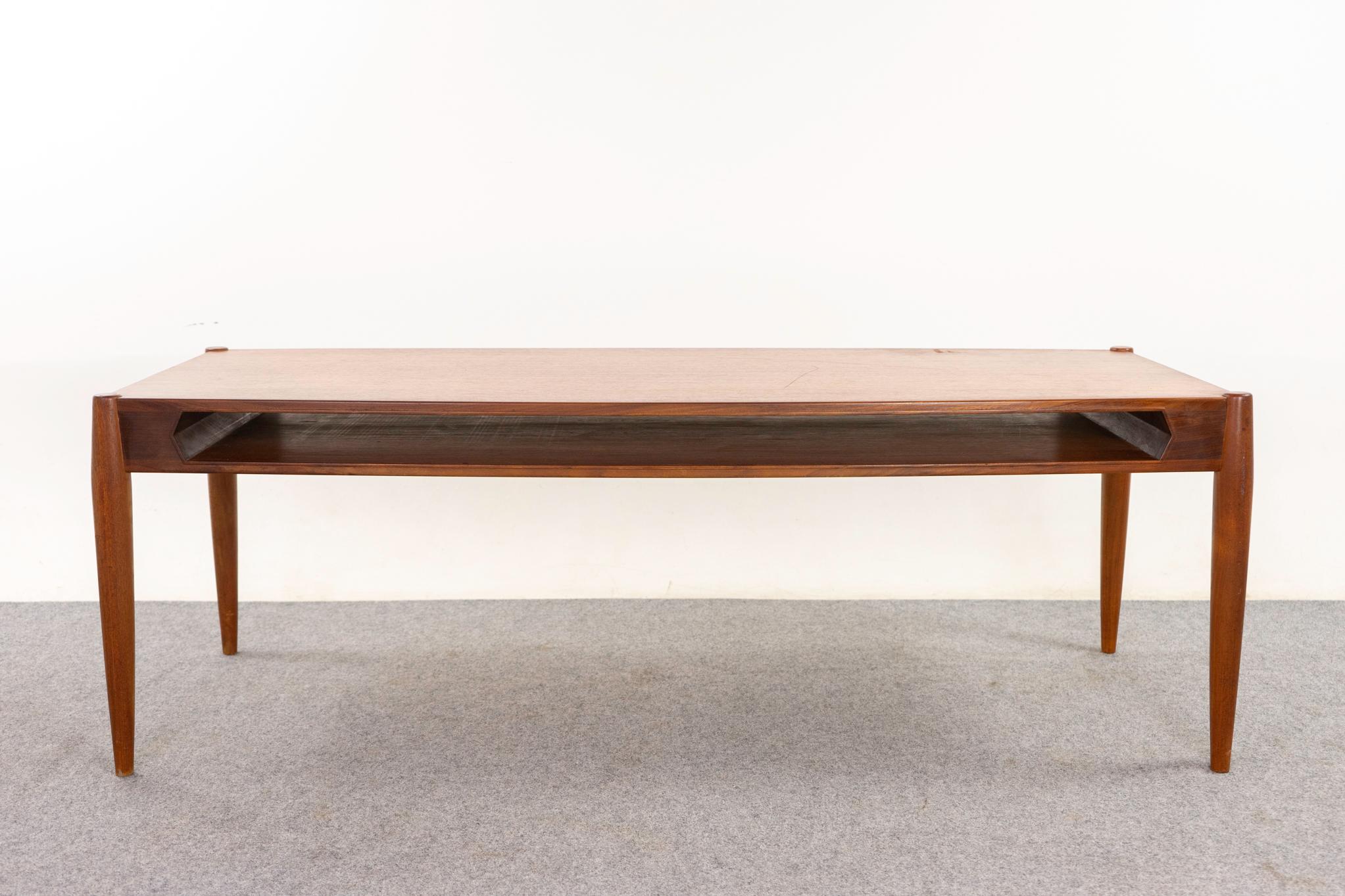 Table basse danoise en teck, circa 1960. Plateau en placage assorti aux livres et garniture en bois massif. Pieds élégants et effilés. Compartiment pratique pour les magazines, les télécommandes, etc.

Un article non restauré avec l'option d'achat