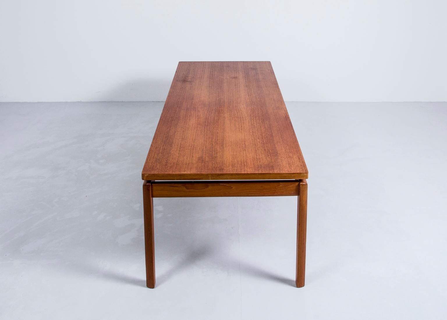 Here is a beautiful large rectangular coffee table designed by Ole Wanscher, circa 1960s. It features a large floating table top with a glowing teak grain resting on four skinny sculpted solid teak legs.
The table top is marked underneath.