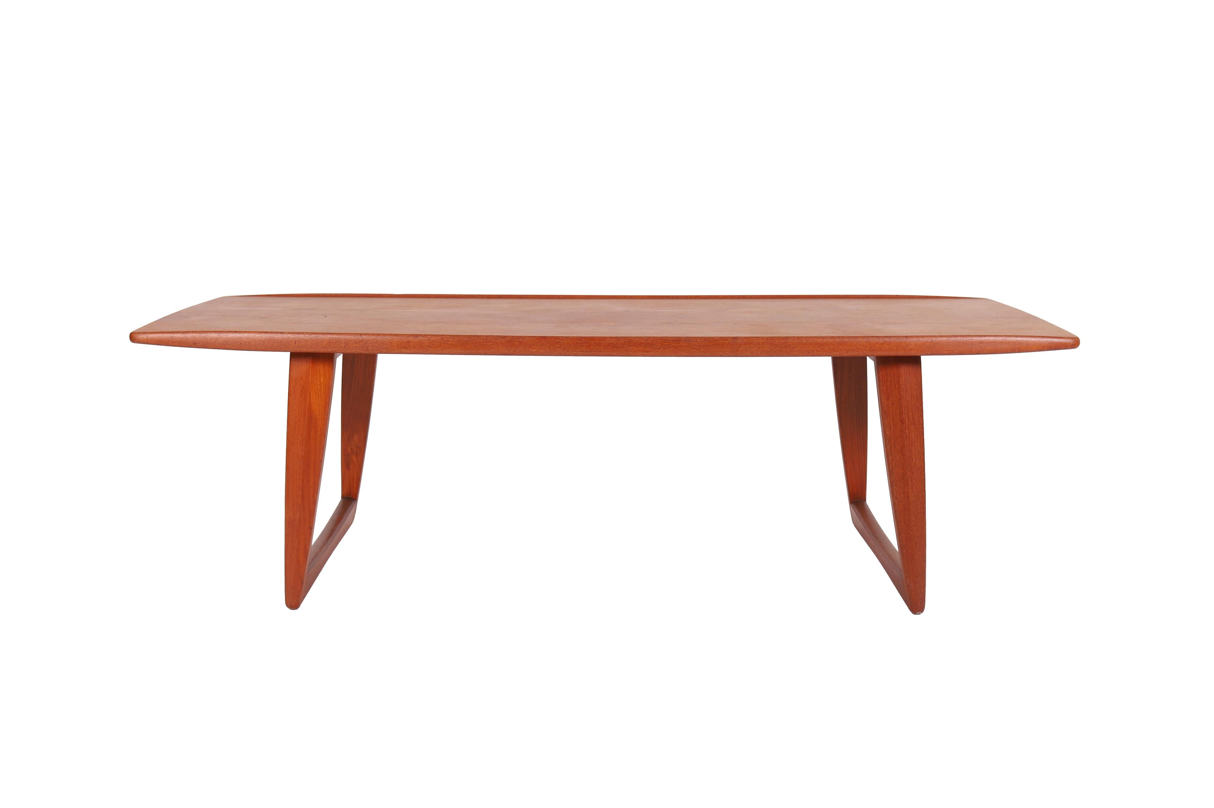 Cette table basse moderne danoise en teck présente un attrait sculptural qui s'harmonise avec un design à thème nordique ou un espace urbain contemporain. Les bords surélevés empêchent les objets de glisser de la table tout en ajoutant à son