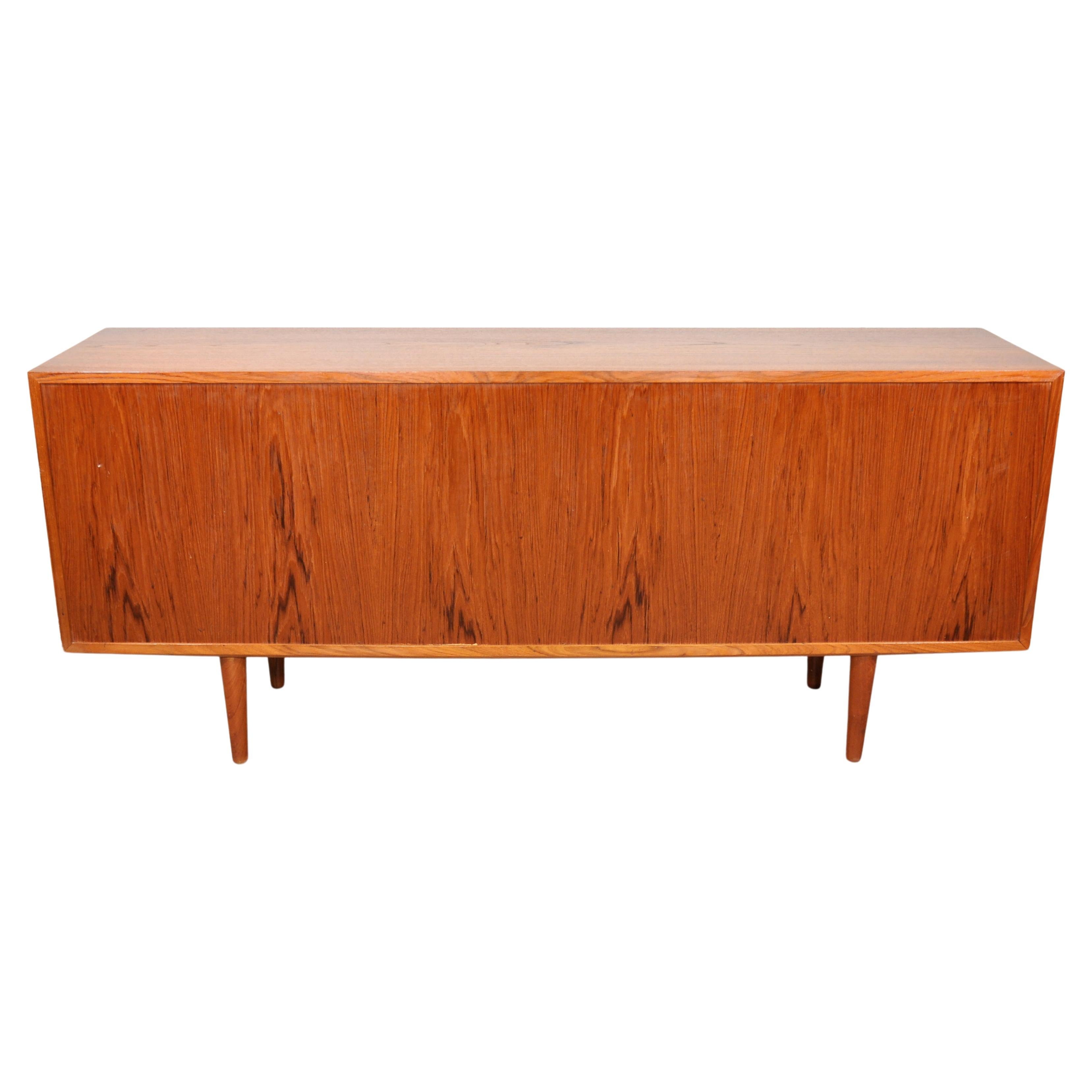 All original gorgeous Mid-Century Modern teak and maple cabinet from the 1960s. The vintage Danish sideboard features a pair of sliding doors, each with a sculpted teak handle, opening to a maple interior fitted with three adjustable shelves, a