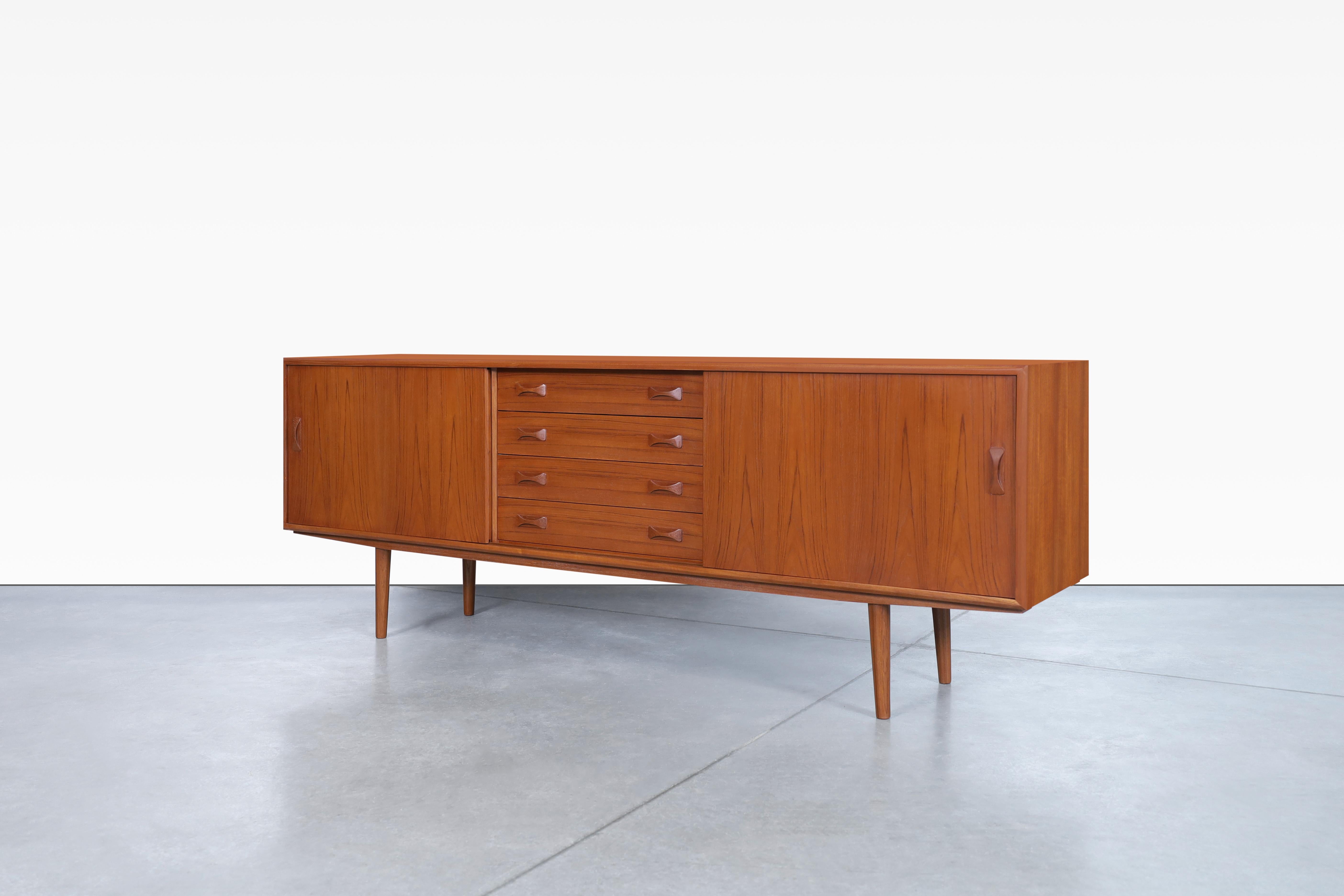 Wonderful teak credenza designed in Denmark for Clausen and Son, circa 1960s. This credenza has an elegant and functional design where the grains of teak wood stand out, which offers a beautiful contrast of colors and figures throughout the entire