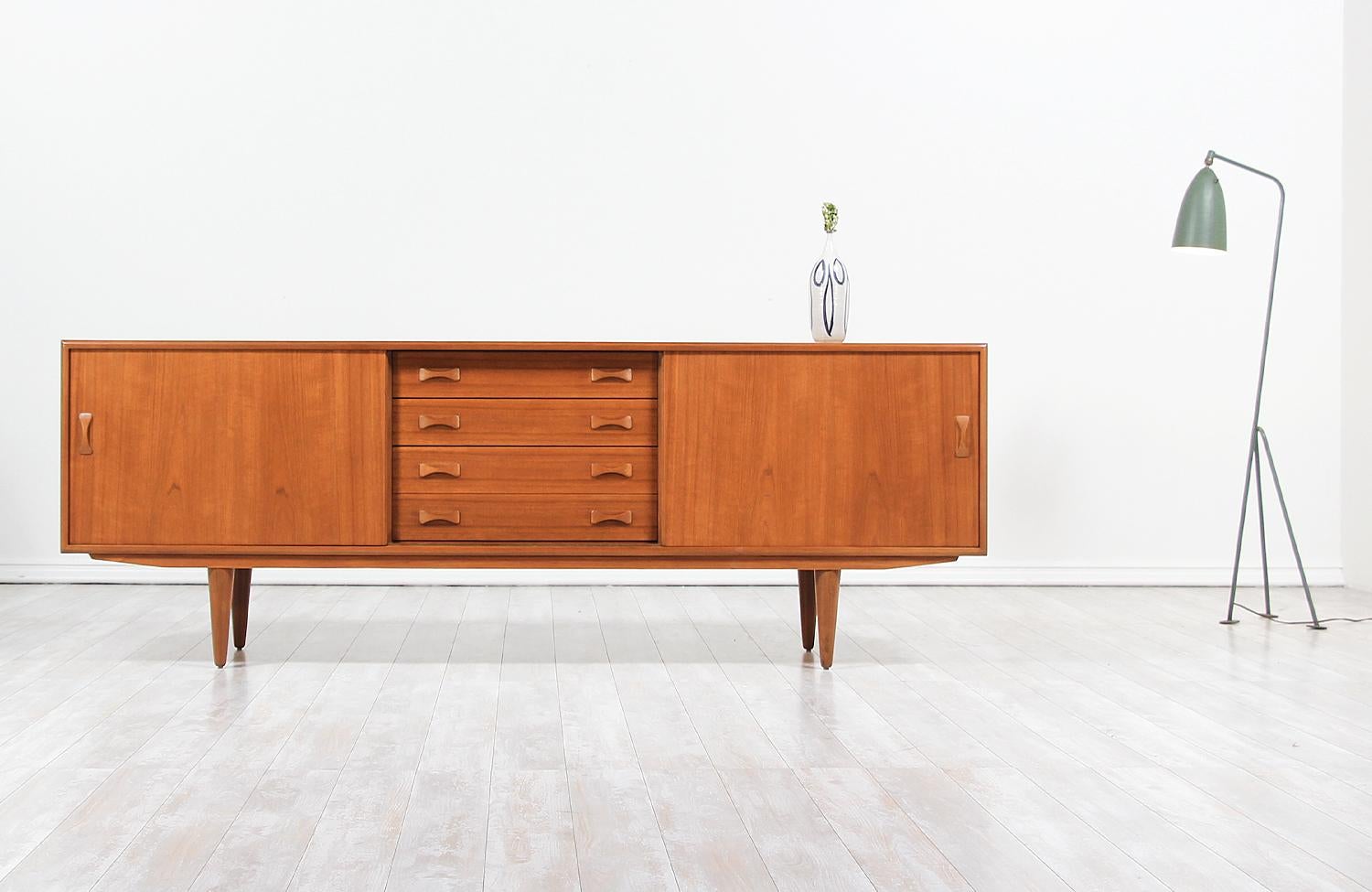 Mid-Century Modern credenza designed and manufactured by Clausen & Søn in Denmark, circa 1960s. This beautiful credenza features a sturdy teak construction over four tapered legs and a beautiful teak grain, adding a warm accent to this stylish