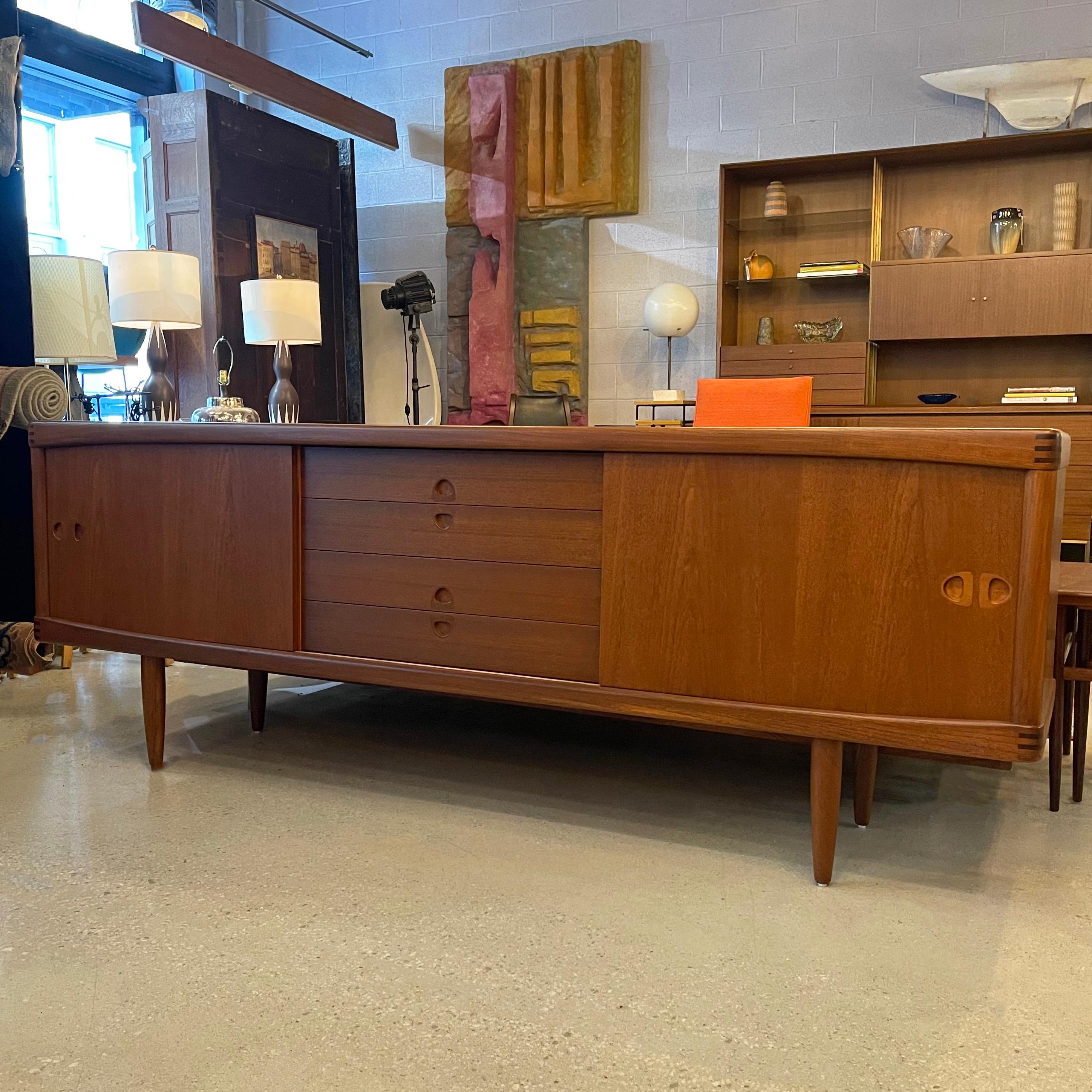 Danish modern, teak, credenza / sideboard by H.W. Klein for Bramin Mobler features sliding doors on either side with exposed drawers in the middle with recessed guitar pick pulls. A TV frame with rosewood inlay at each corner encases the front and