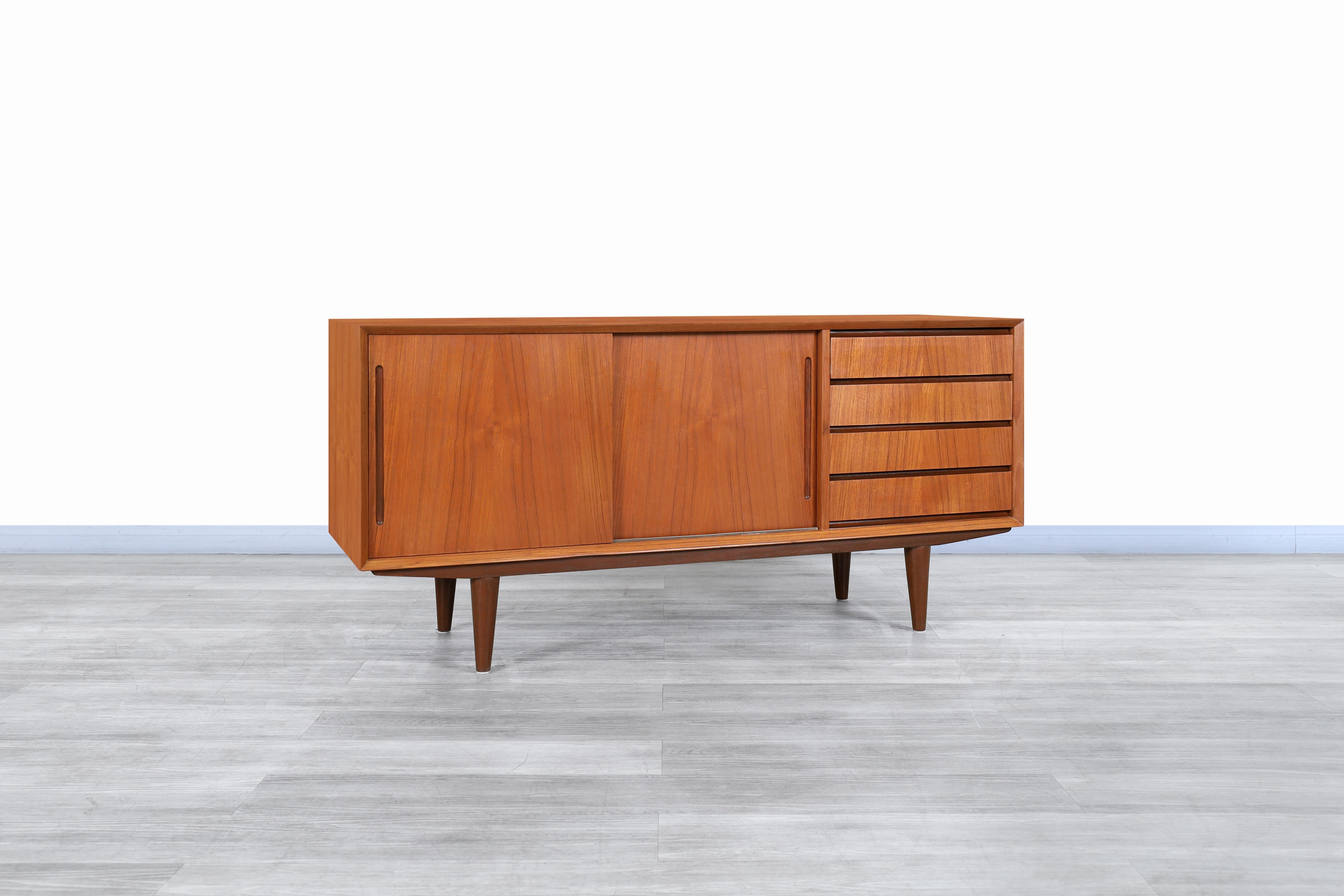 Wonderful Danish modern teak credenza manufactured in Denmark, circa 1960s. This credenza has been constructed from the highest quality teak wood and features a functional and elegant design representative of the Scandinavian era. Features four