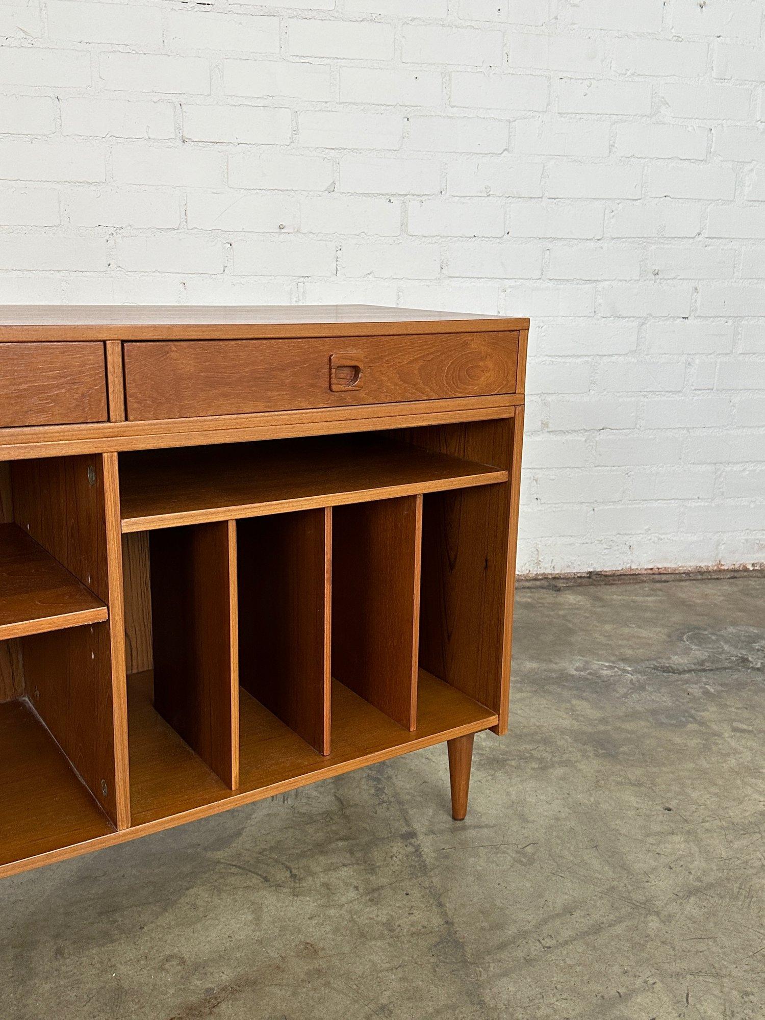 W47.5 D18 H31.5

Fully restored teak credenza in great conditon. Item is strcutrally sound and features removable shelving and record dividers. Item sits on solid wooden tapered legs and has features sculpted handles. 