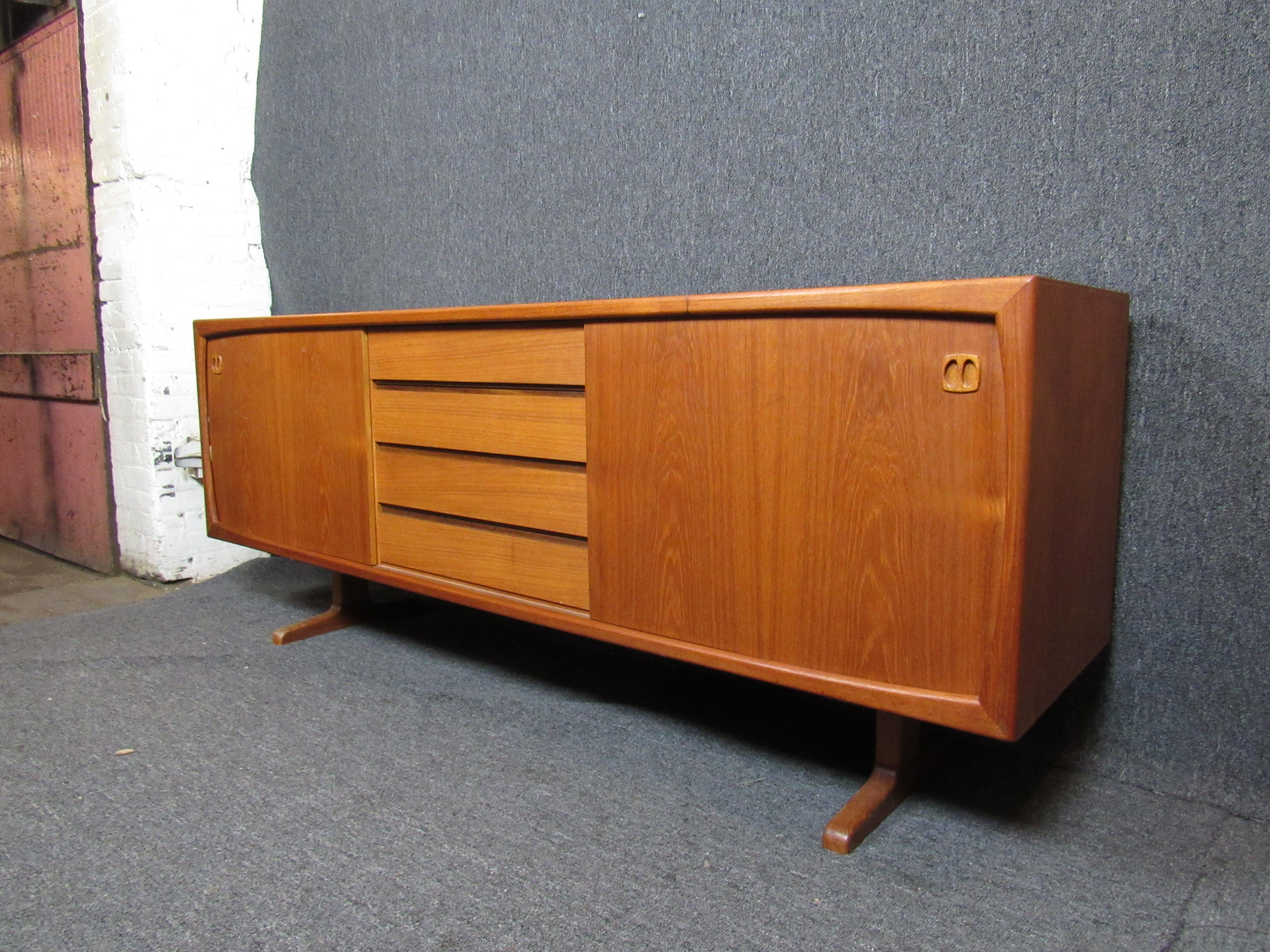 Mid-century modern teak credenza featuring sliding doors and four slim drawers in the center.

(Please confirm item location - NY or NJ - with dealer)