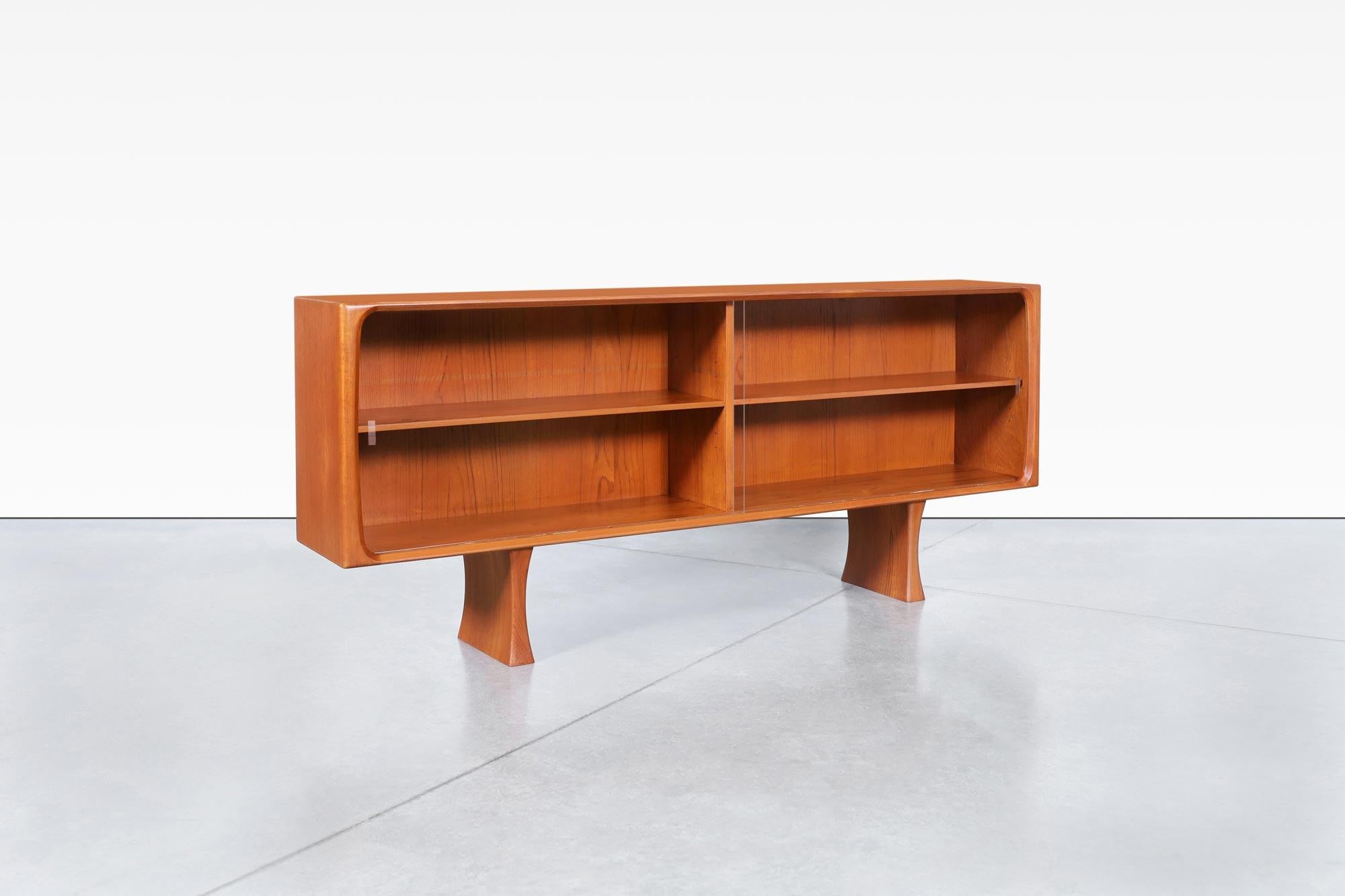 Splendida credenza danese moderna in teak con ante in vetro progettata da Bernhard Pedersen in Danimarca, intorno agli anni '60. Questa credenza ha un design minimalista ma altamente funzionale, dove il legno di teak spicca grazie alle venature del