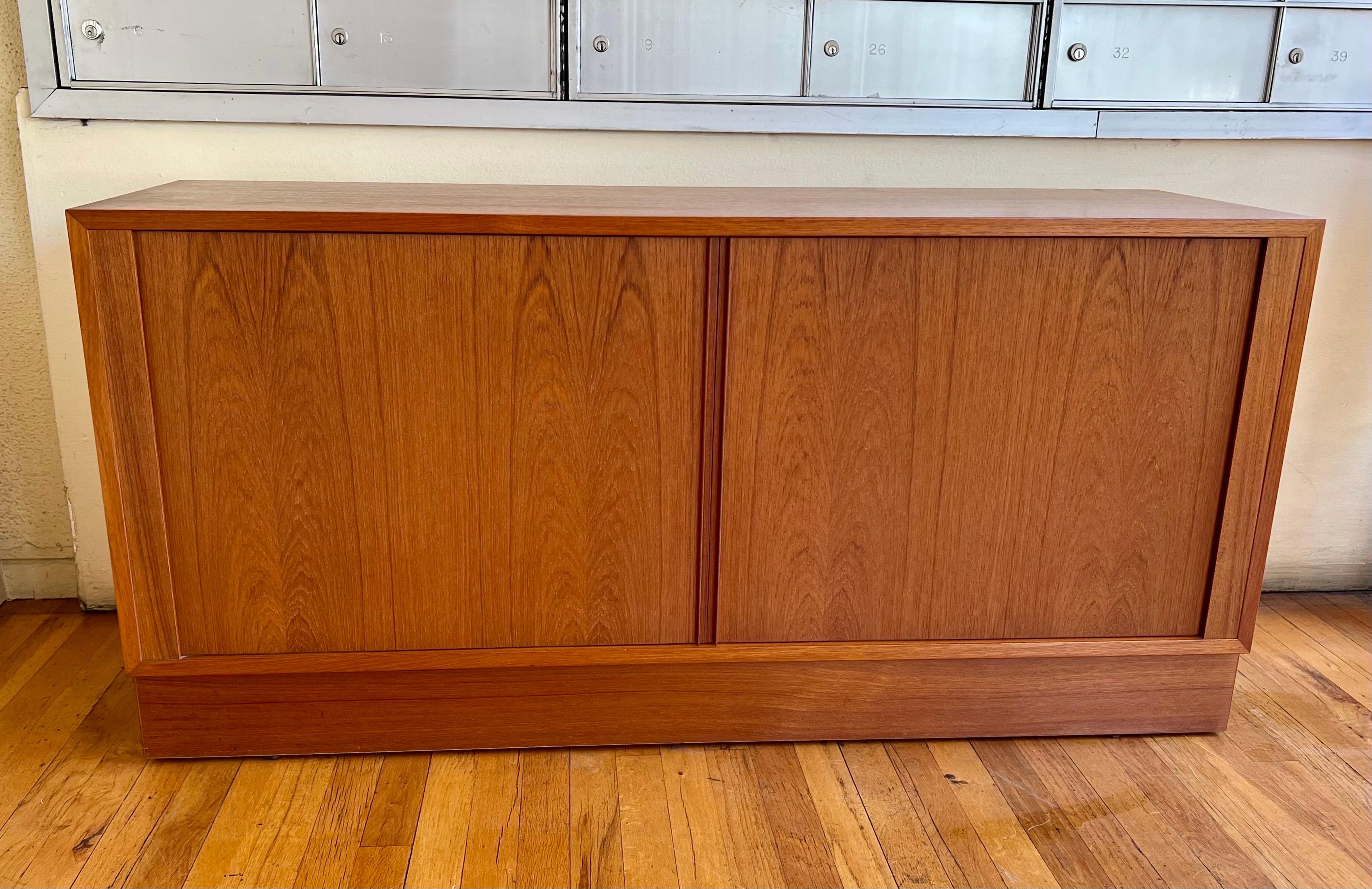 Versatile tambour door teak credenza by Carlo Jensen for Poul Hundevad. Made in the 1960s in Denmark, it features super thin vertical pulls running the length of the doors. The secondary wood is birch and the divided, nice clean original finish.