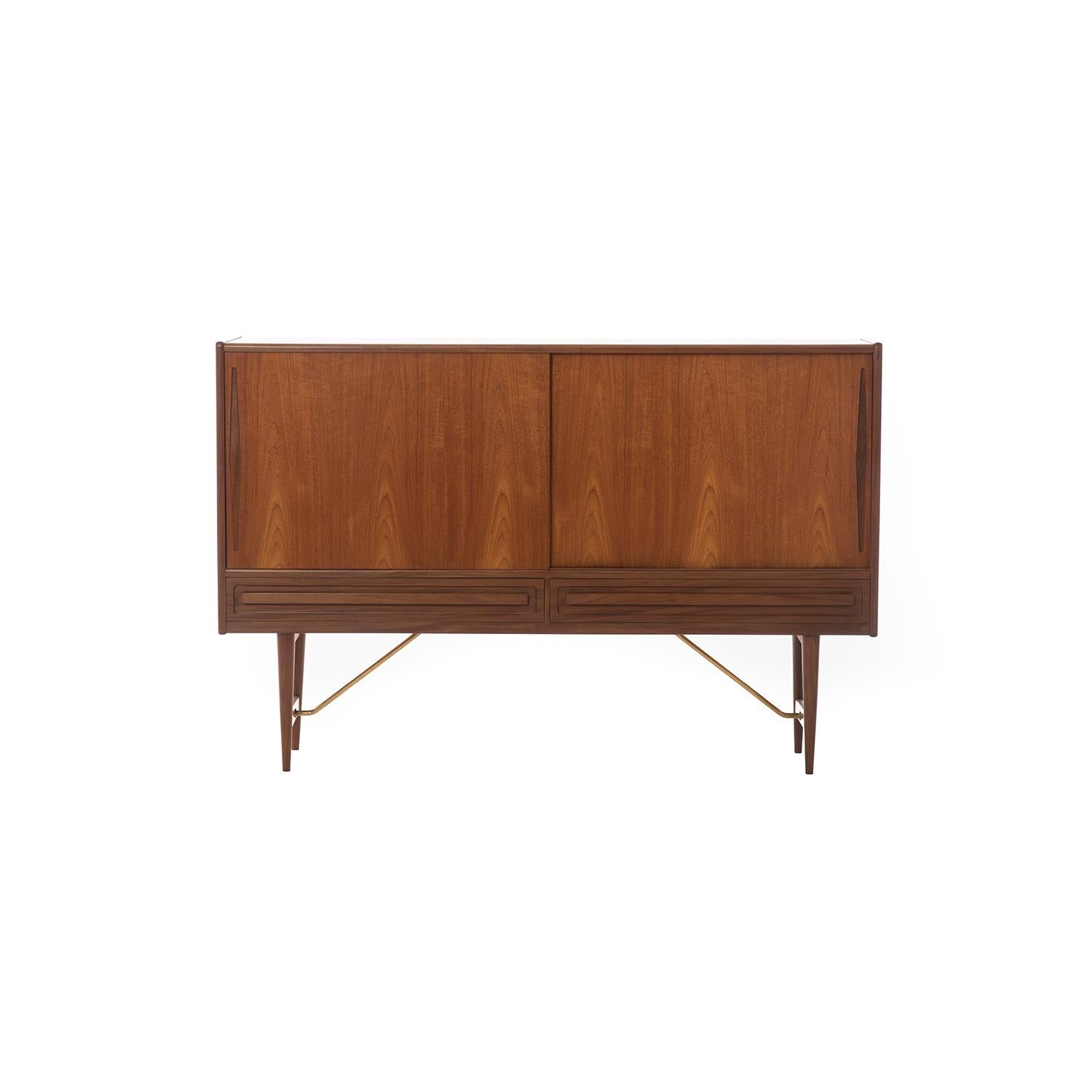 Danish modern old growth teak sideboard with brass hardware. Features adjustable shelves, five silver drawers, and two larger linen drawers.