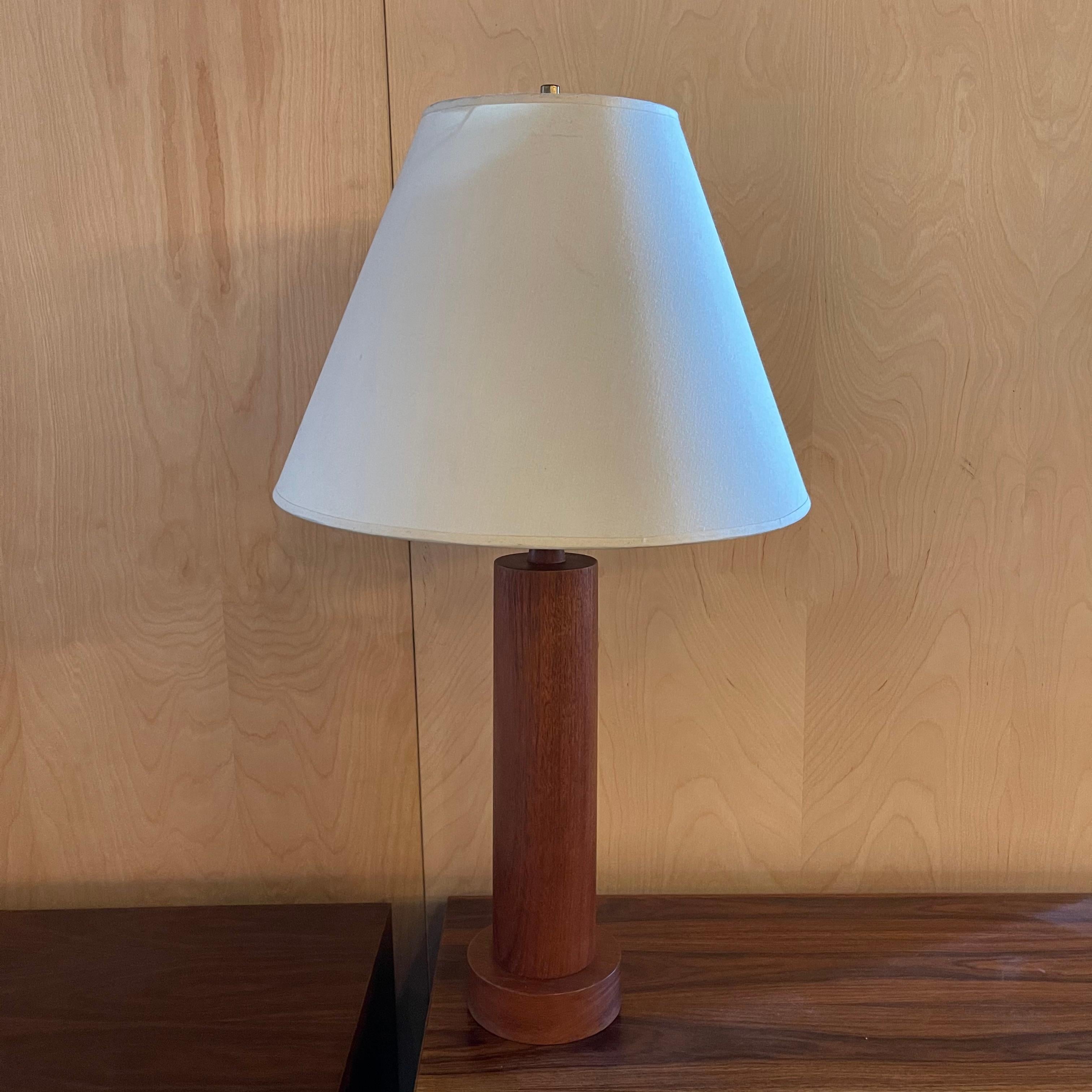 Danish modern table lamp features a solid teak cylinder base and cream linen fabric shade that measures 13 inches height x 8-18 inches diameter.