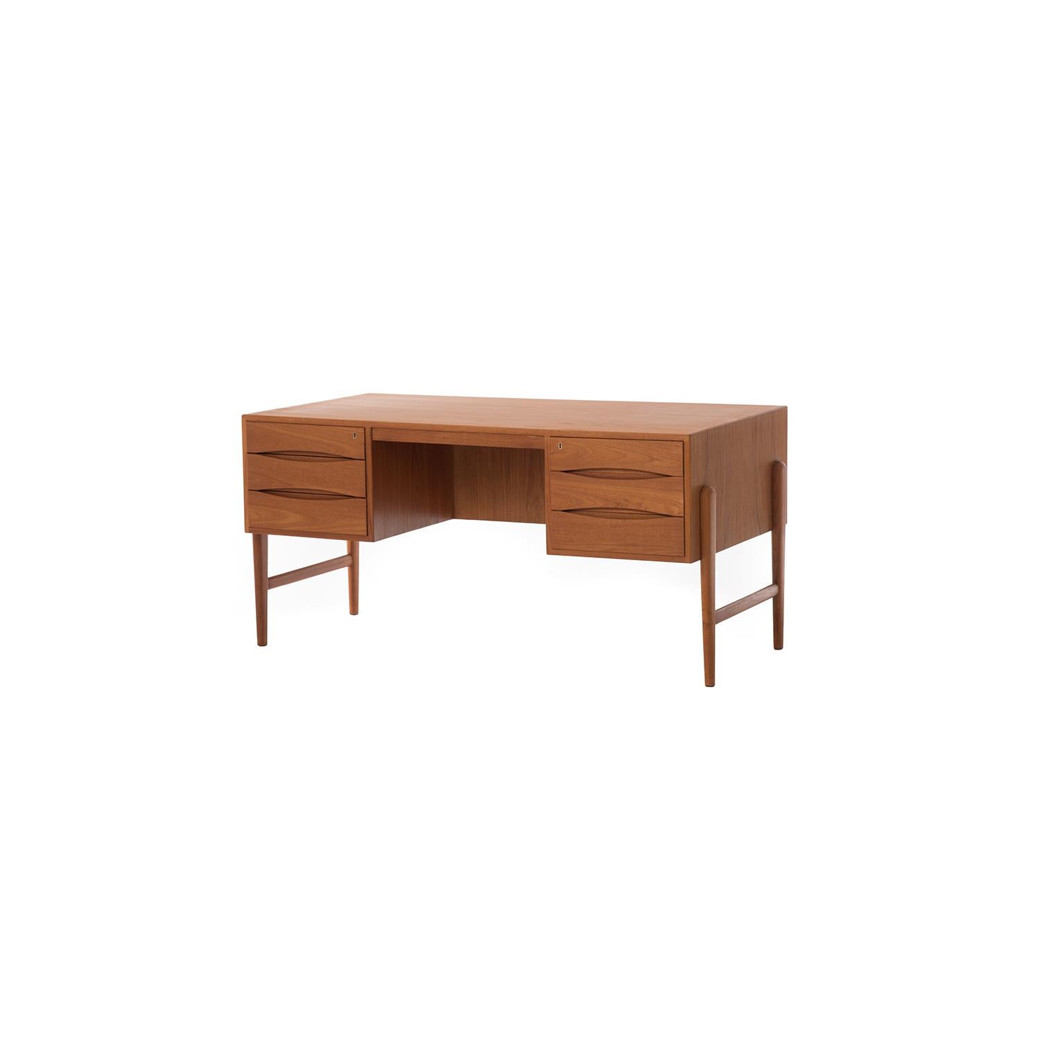 This large teak desk features six drawers (two locking) on the user side, as well as an open shelf/cubby space for additional storage on the backside.