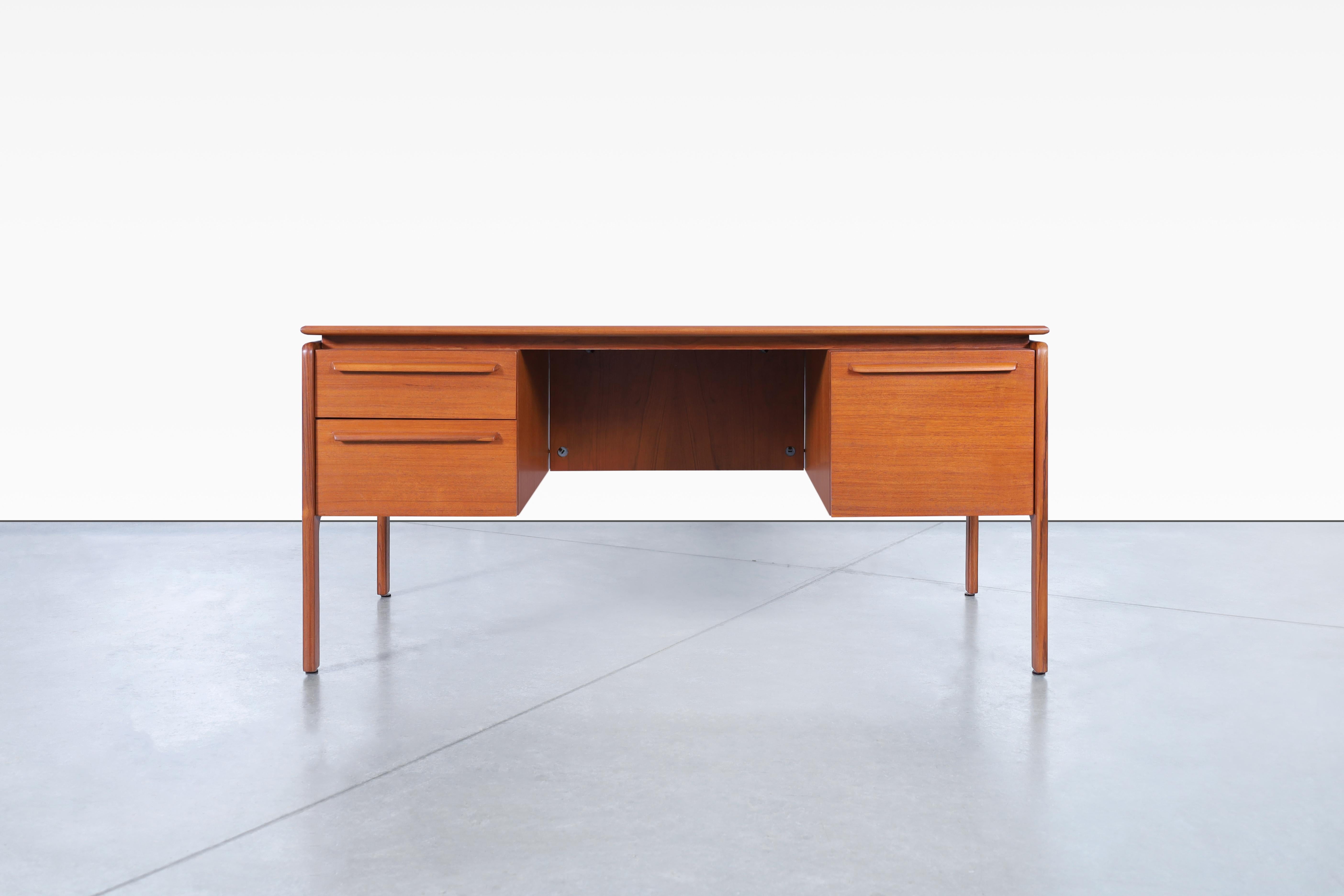 Stunning Danish modern teak desk manufactured by Danflex in Denmark, circa 1960s. This desk has an innovative design where you can appreciate the fine attention to details and the grain that makes up its structure. The left side features two