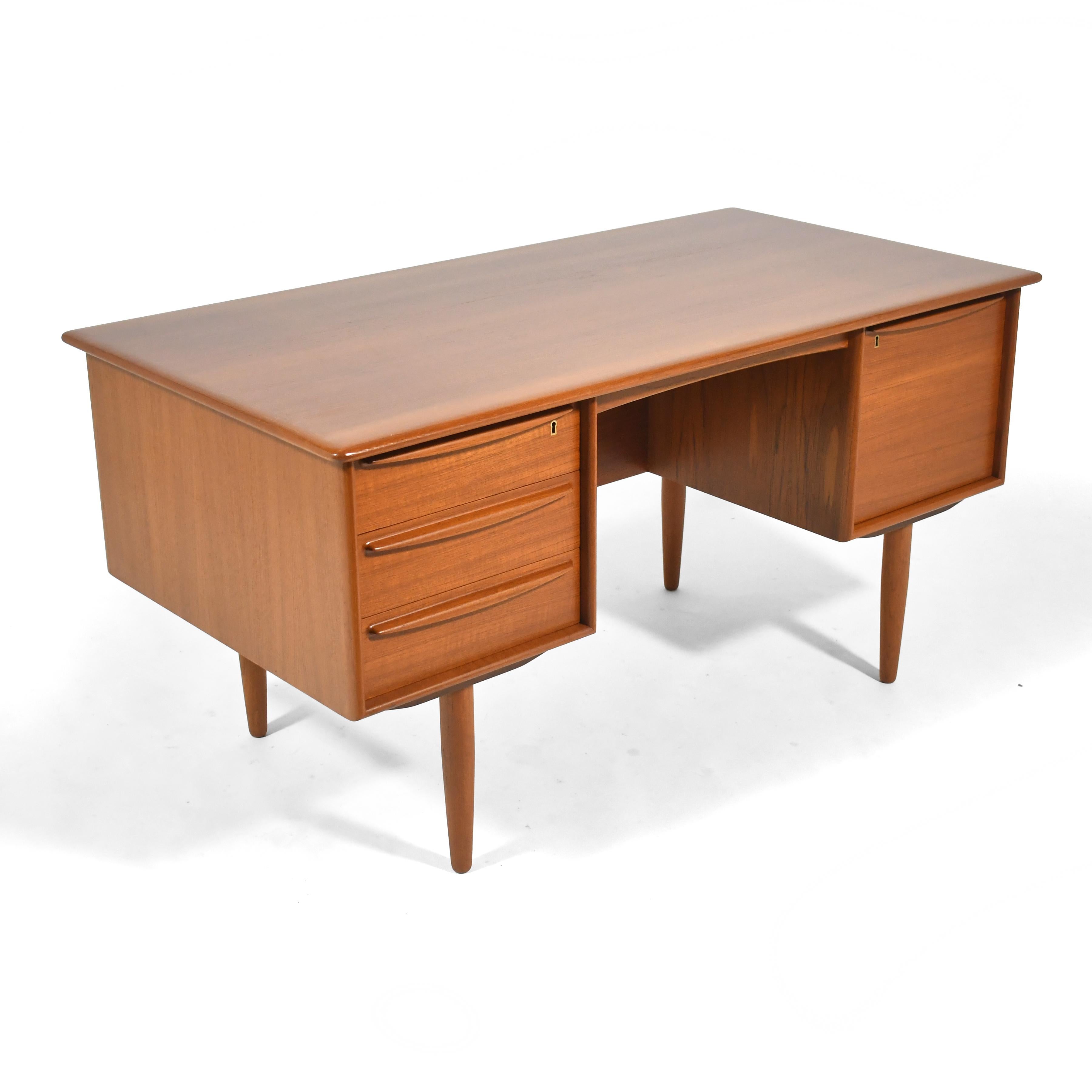 This handsome and incredibly well built Svend Madsen desk by Falster Mobelfabrik has a bank of three shallow drawers on the left and a deep file drawer on the right. The back features a large storage compartment for books or displaying art/