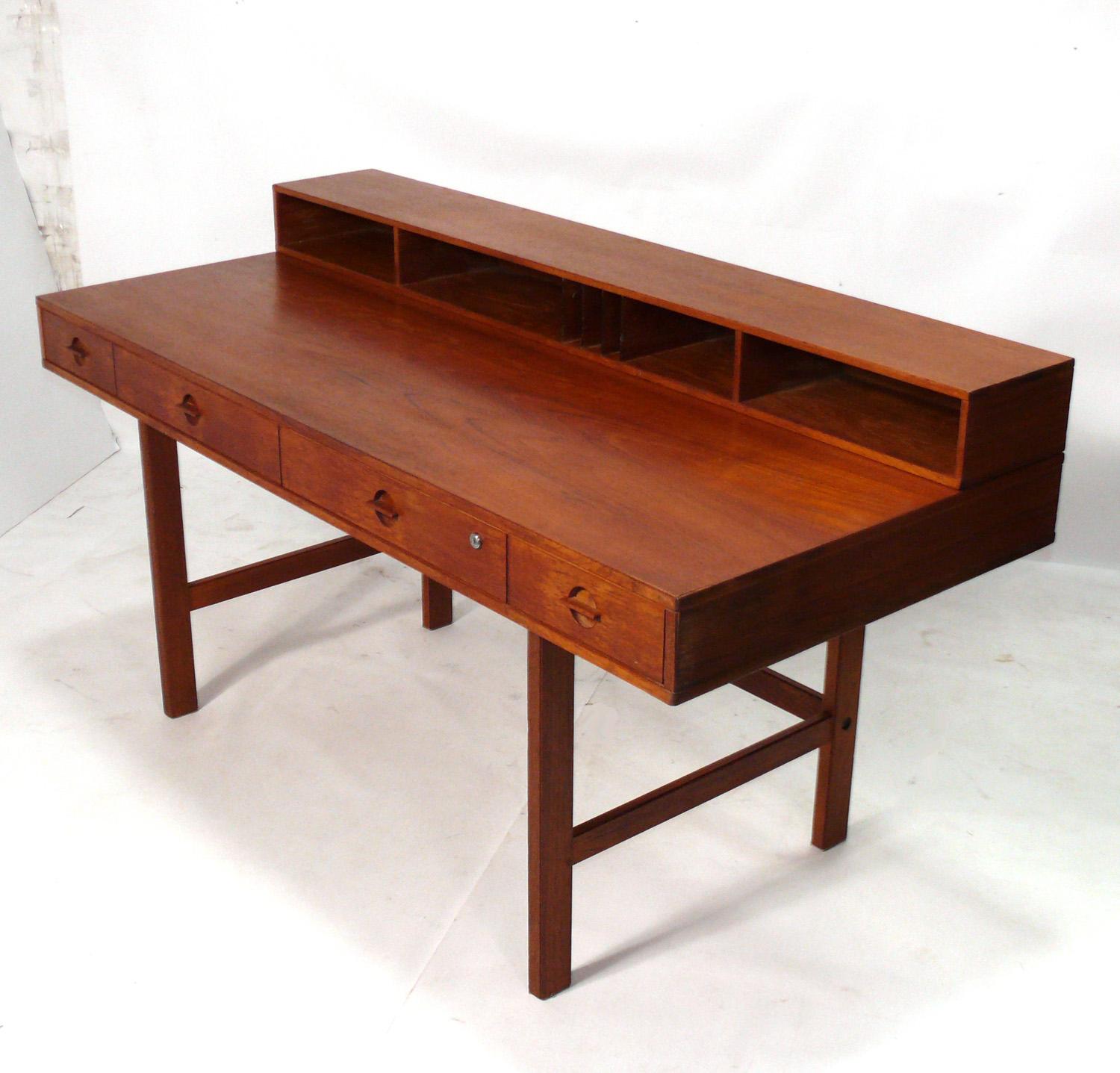 Clean lined Danish Modern teak desk, designed by Peter Lovig Nielsen for Lovig, Denmark, circa 1960s. This desk is currently being refinished and will look incredible when completed. The price noted includes refinishing. The desk has an ingenius