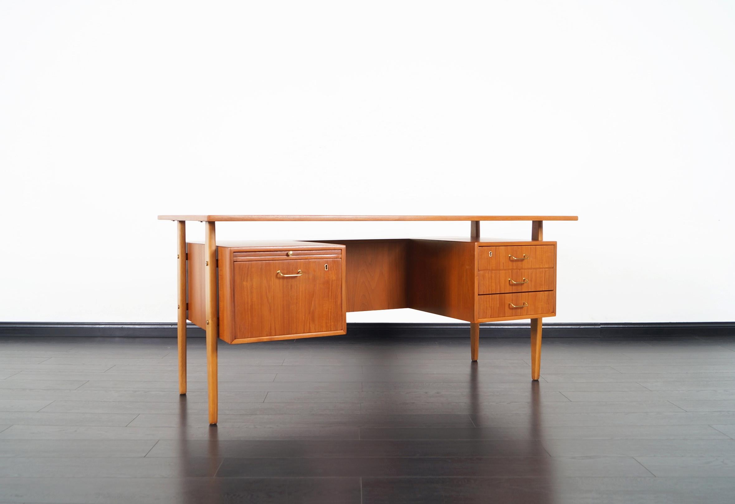Amazing Danish modern teak desk designed by Torben Standgaard for Falster Møbelfabrik. This freestanding desk features a floating top design. Includes three drawers on the right side and a file drawer with pull-out writing surface on the left side.