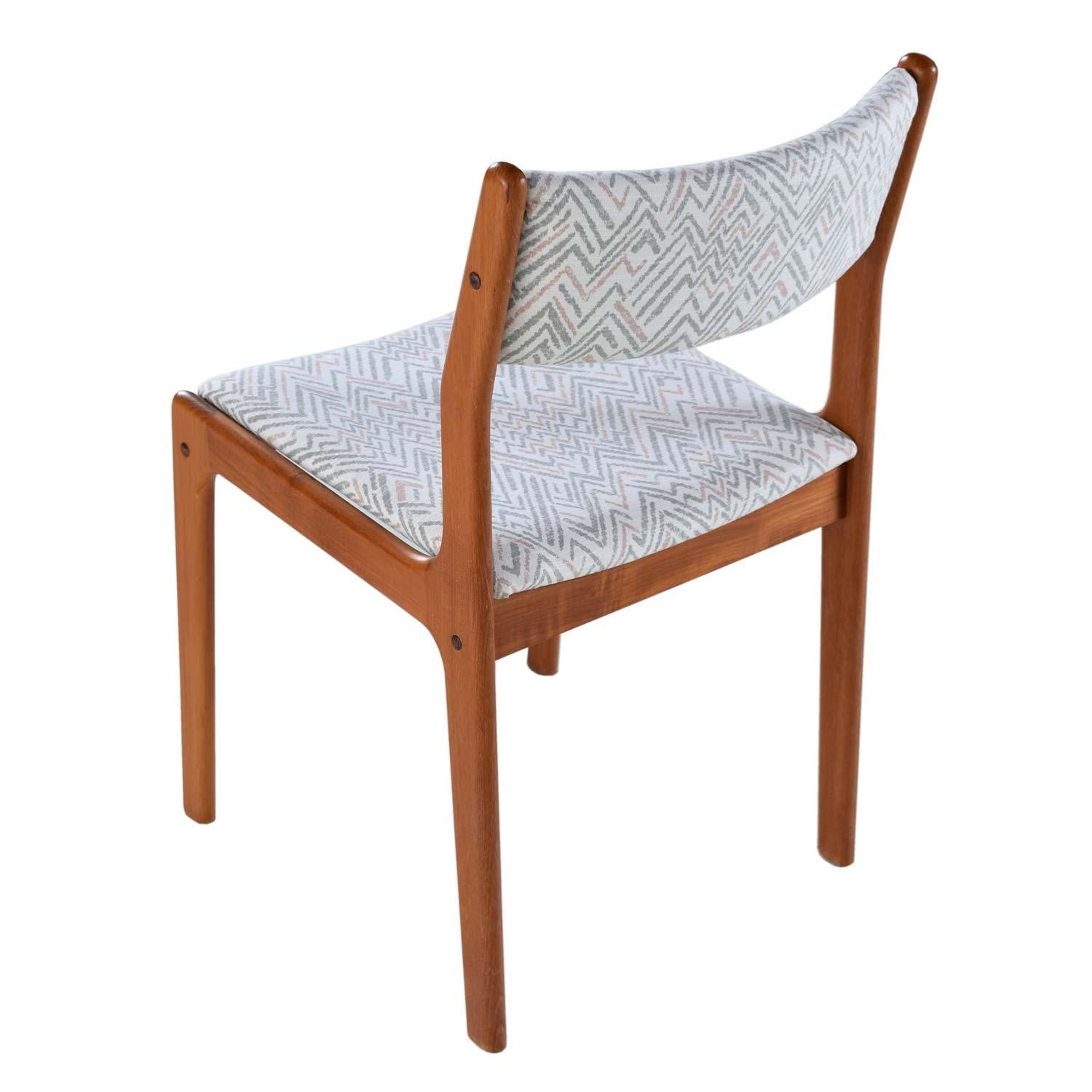 This set of six vintage teak dining chairs have a contemporary flair with their new upholstery. The previous owner updated the solid teak wood chairs with this stylish modern fabric, propelling them into the 21st century. These chairs would look