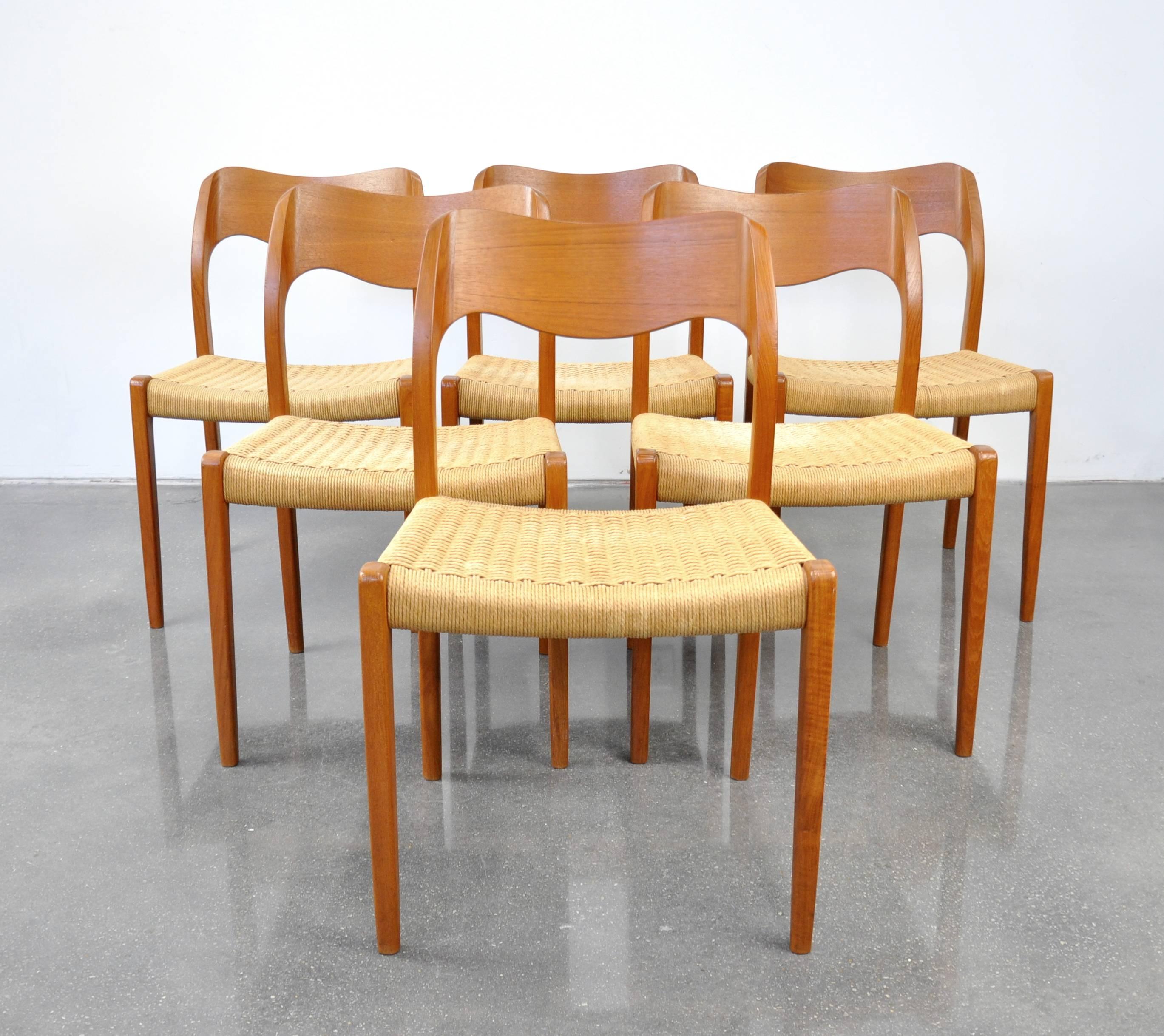 A vintage Mid-Century Modern teak dining set including a professionally restored draw-leaf extension dining table and a set of six model #71 chairs designed by Arne Hovmand-Olsen for J.L. Møllers Møbelfabrik in Denmark, dating from the 1960s. The