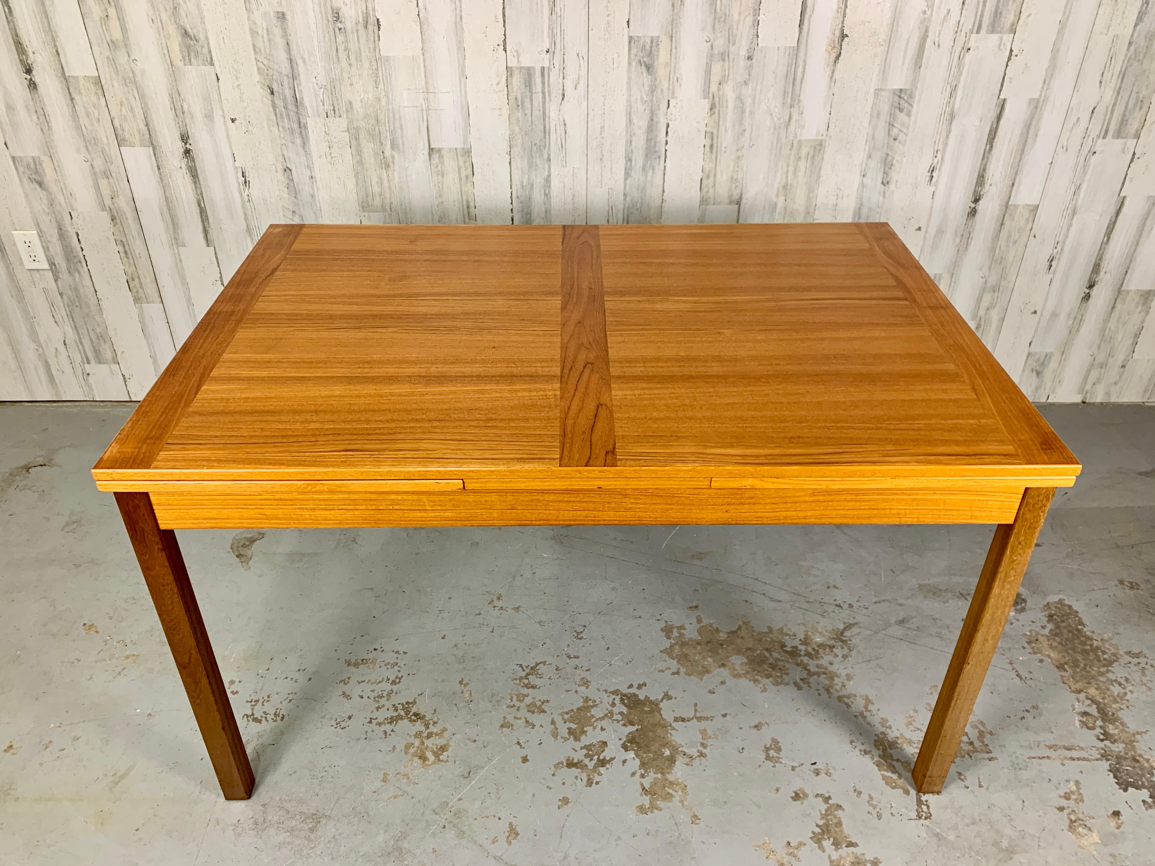 Combination of solid teak and veneer make this a beautiful dining table for 20th century living. Retractable leaves that pull out from underneath the table top make this a very practical and easy to use table.

 Table measures 92.5 inches long
