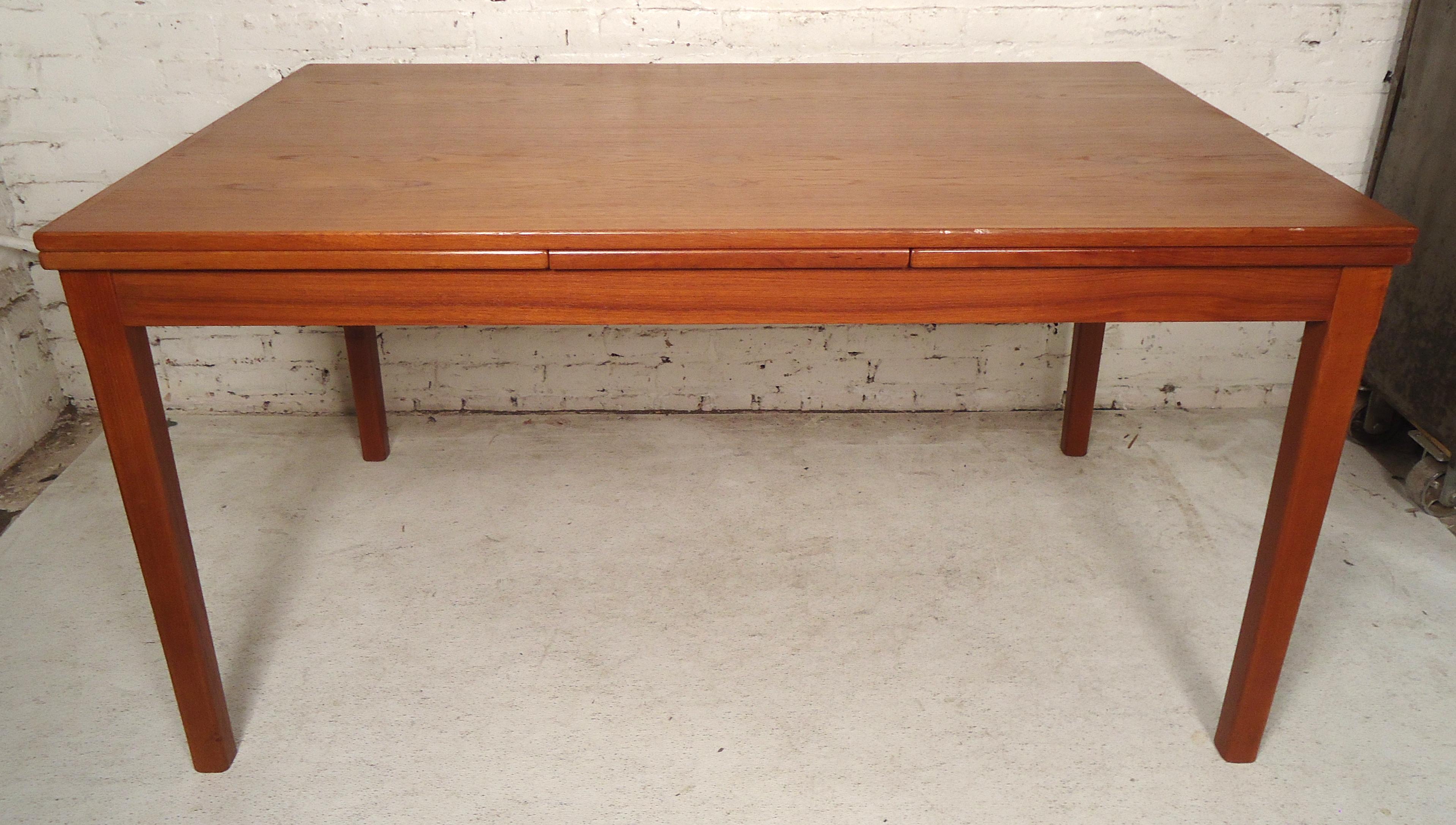 Mid-Century Modern dining table with pullout / pull-out leaves. Warm teak veneer over wood.
Measures: Closed 54