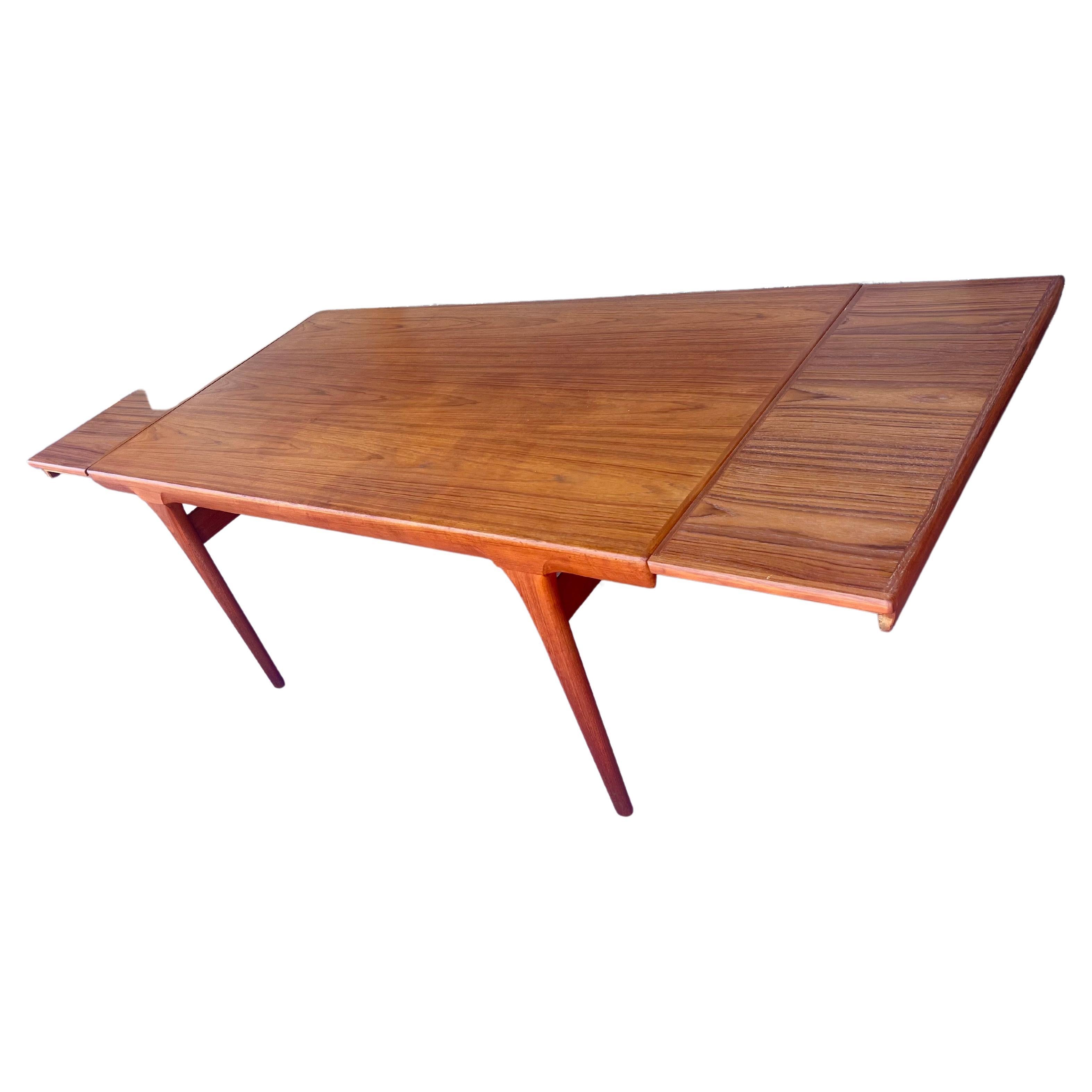 Magnifique table en teck moderne danois avec double feuilles qui se cachent sous le dessus de table, chaque côté se retire et la table repose sur le dessus et se ferme, cette pièce est en très bon état, la table fait 68' de long sans les extensions