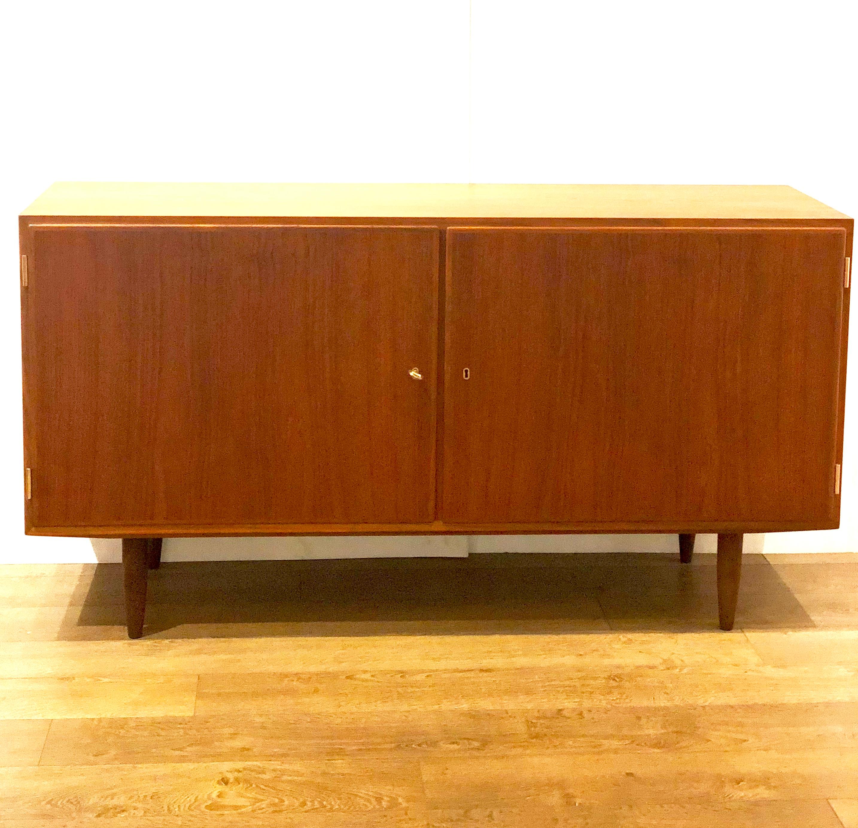 Versatyle double door cabinet designed by Hovmand Olsen in teak, with original brass key for the doors, shelves on one side drawers on the other side, this piece its high quality design and has the Danish control tag and its stamped in the back, the