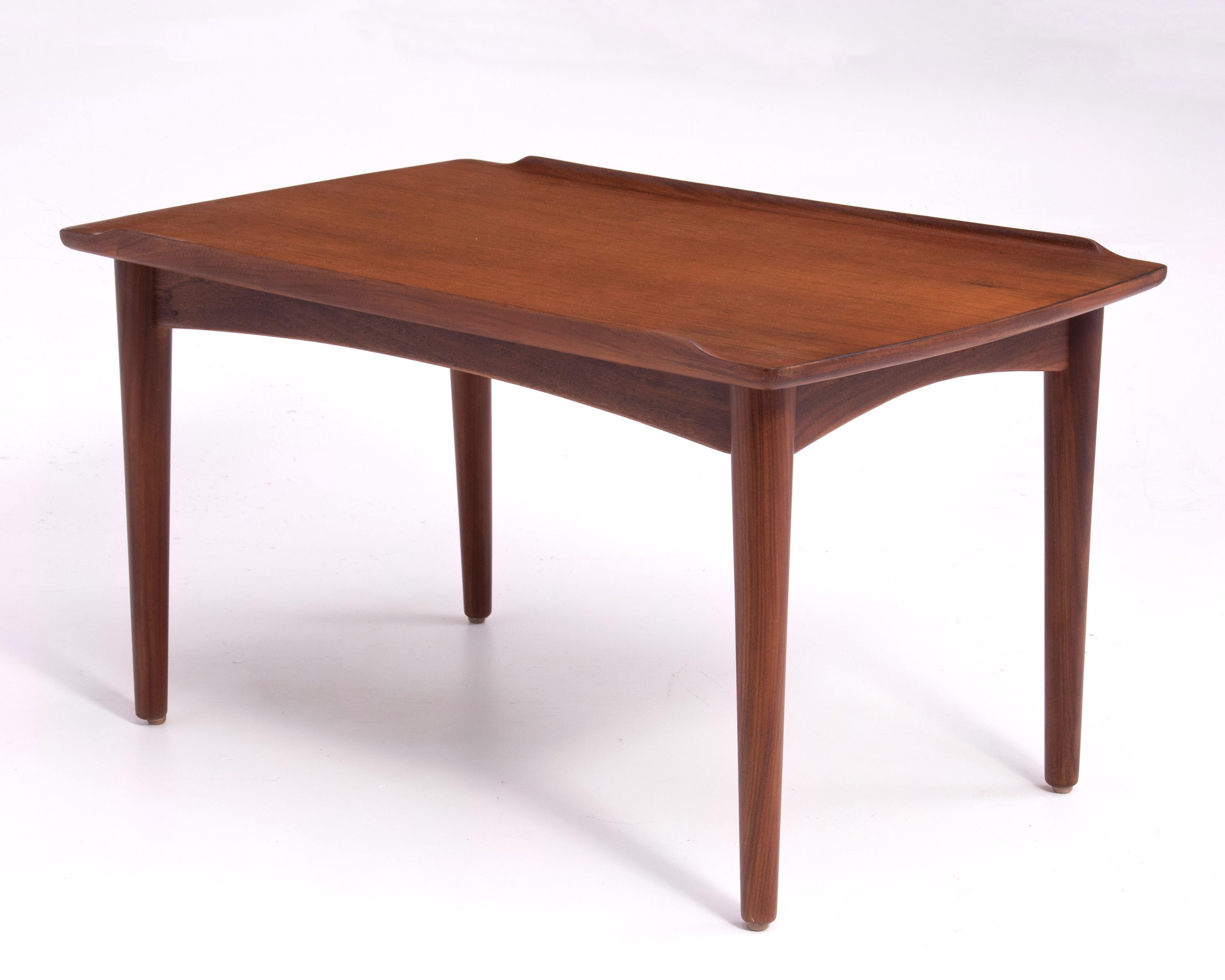 A very nice Danish Modern teak side table after Grete Jalk for Glostrup Furniture. Dowel legs and arched stretchers. Marked 