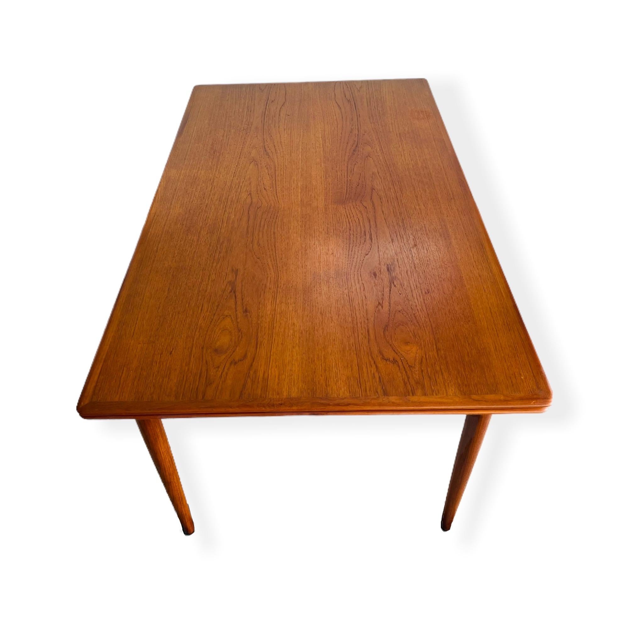 Stunning large Mid-Century Danish Modern teak draw-leaf extension dining table designed by Skovmand & Andersen for Moreddi. This table has built in leaf on each side that slides/hide under each side of the table. This table can easily sit 10 people