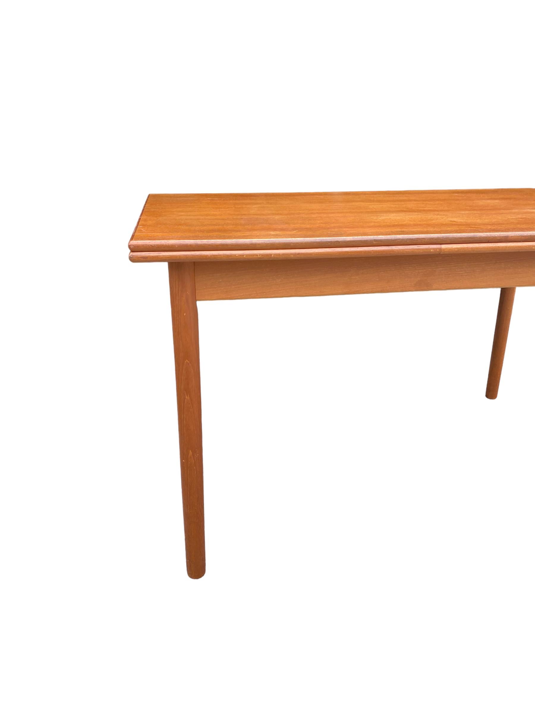 Danish modern dining table with two hidden draw leaf extensions. Teakwood in good condition with wear consistent with age and use. Stamped Made in Denmark by H. Sigh and Sons.