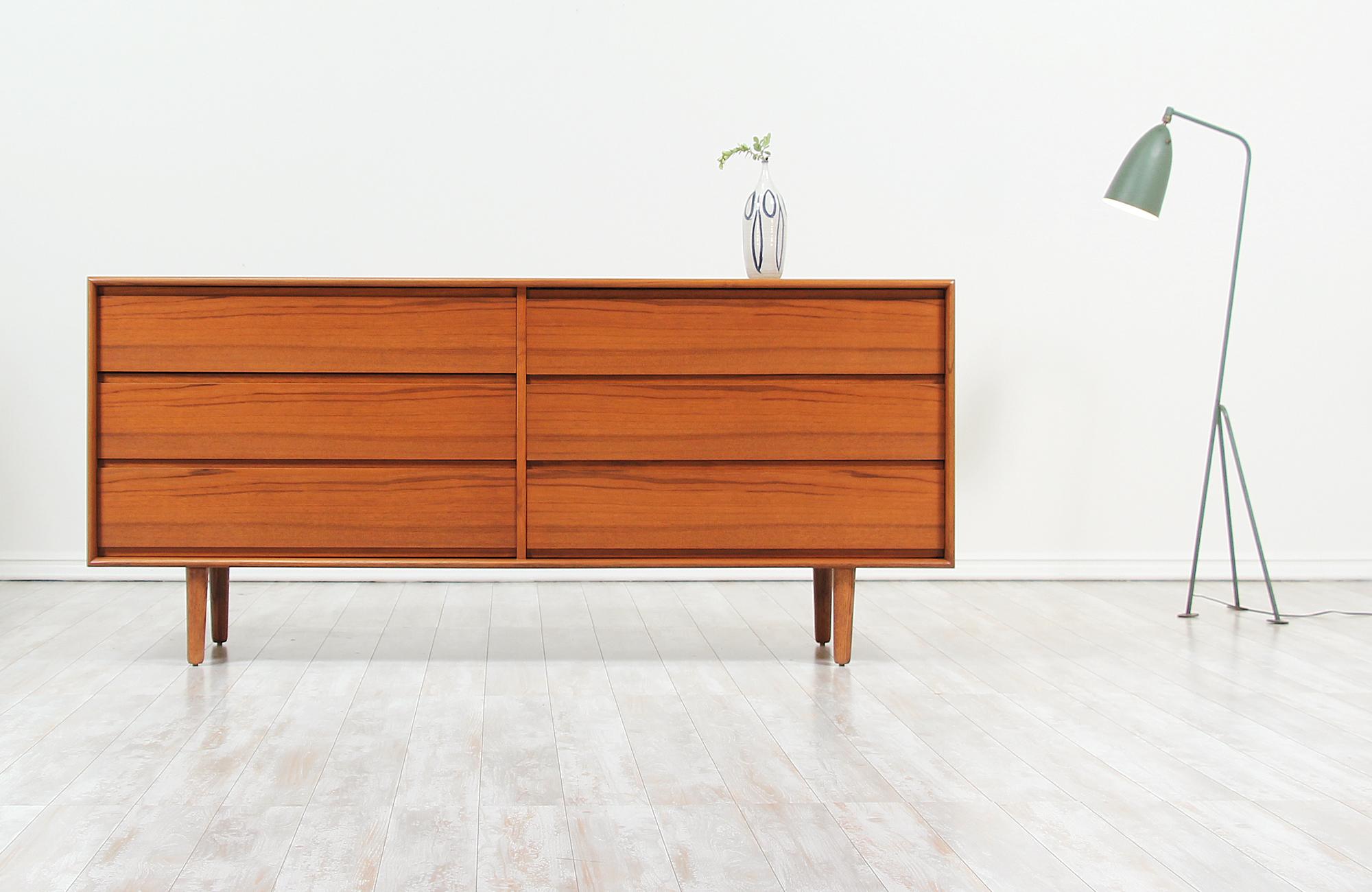 Elegant vintage dresser designed and manufactured by Art Furn in Denmark, circa 1960s. This playful design features a sturdy teak case with six drawers that paly in size and feature sculpted handles for easy opening. With a stable and