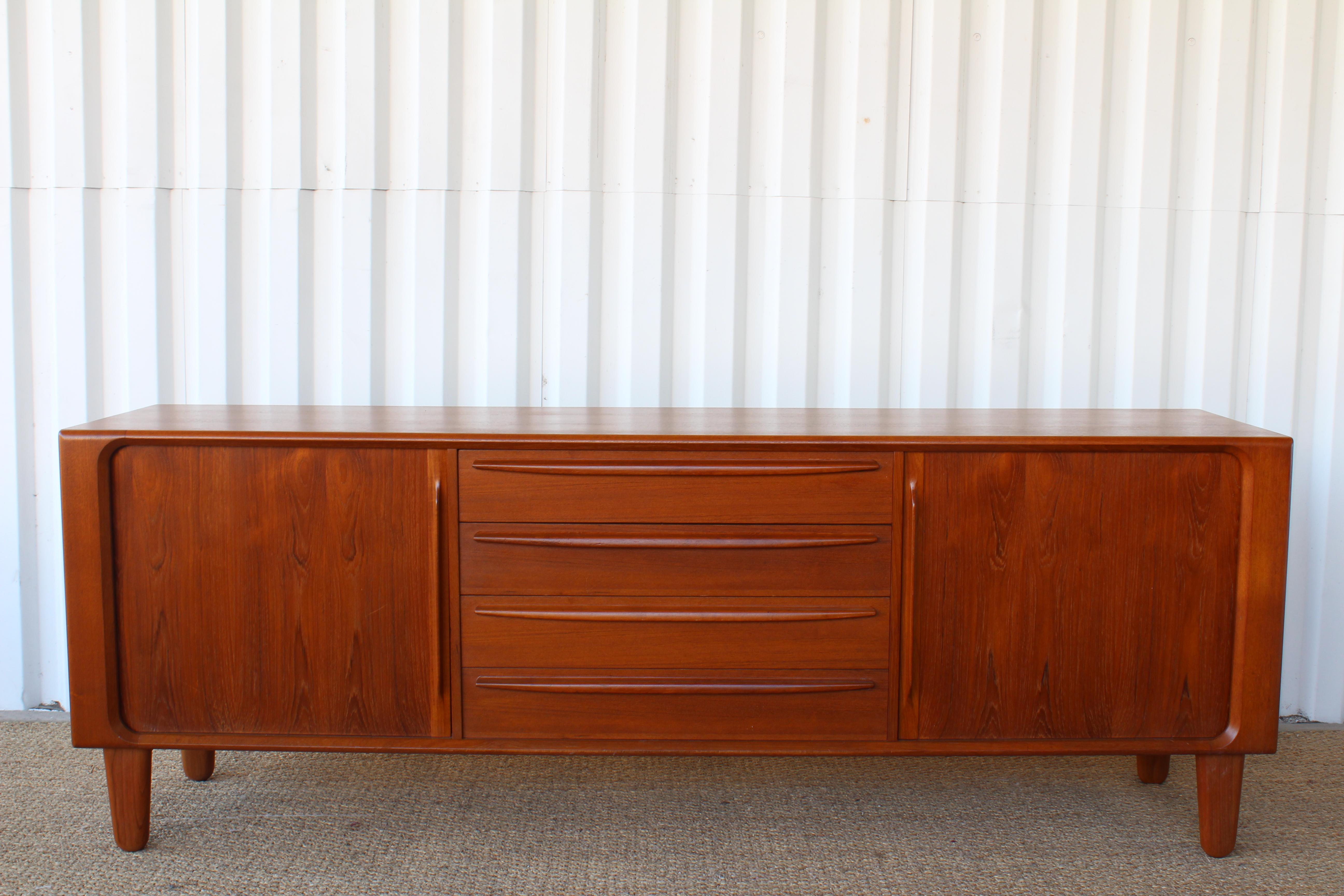 Danish modern solid teak dresser or credenza by Bernhard Pederson & Son from the 1960s. In excellent condition and recently refinished. Exceptional craftsmanship throughout. Features tambour sliding doors, dovetailed drawers, sculpted teak handles