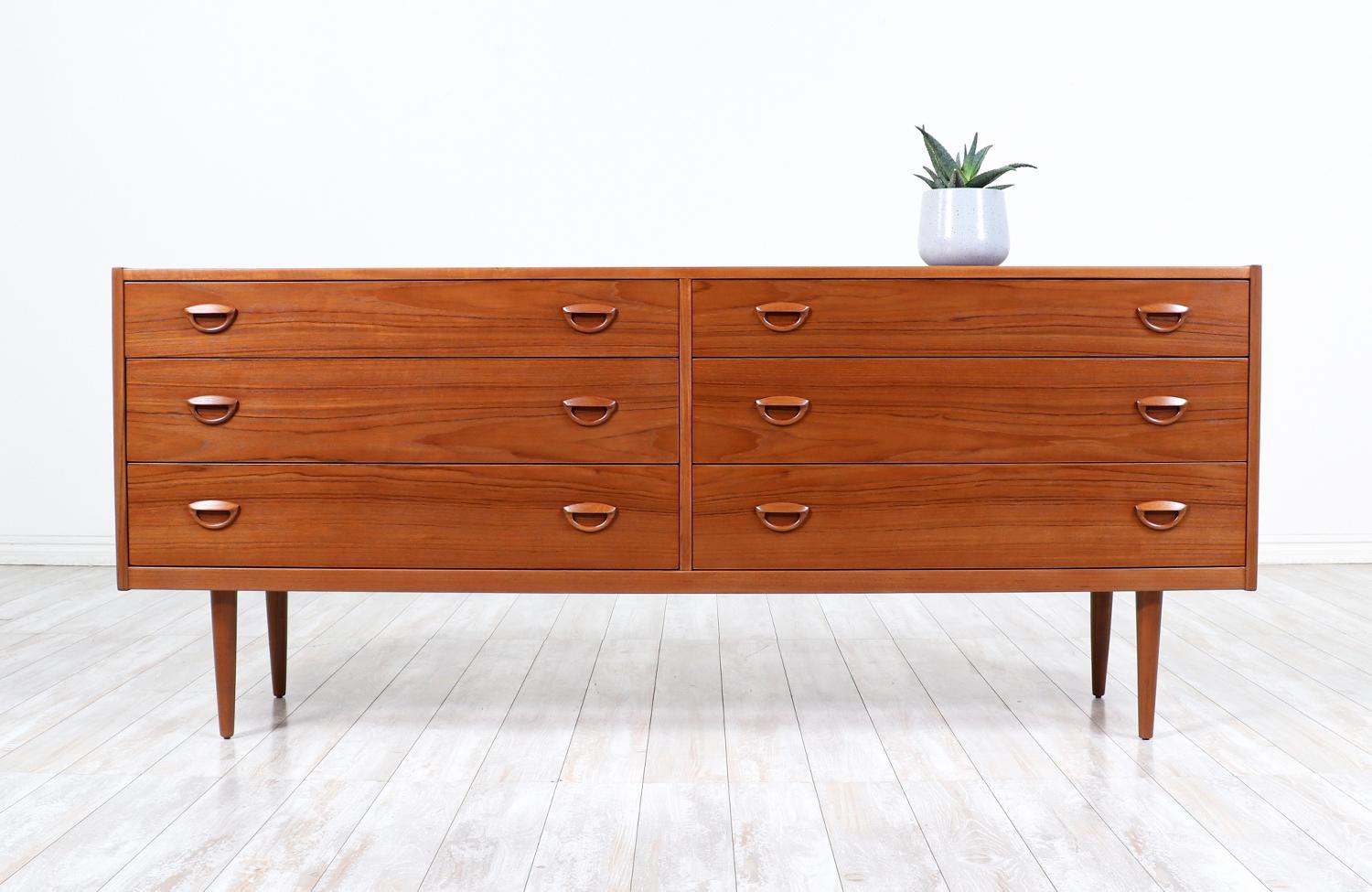 Elegant dresser designed by Kai Kristiansen for Fornem Møbelkunst in Denmark circa 1960’s. This practical dresser is beautifully crafted in teak wood featuring plentiful storage options with recessed carved pulls and six dovetailed drawers. The fine