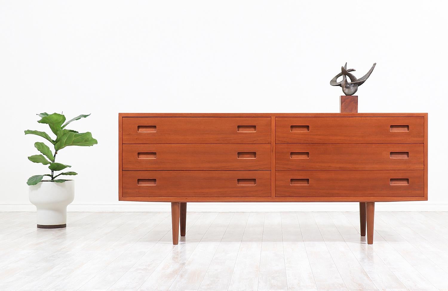 Elegant dresser designed and manufactured in Denmark, circa 1950s. This Classic vintage Danish modern design features six spacious dovetail drawers with recessed pulls and teak grain detail throughout. Delicately crafted with teak wood and sitting