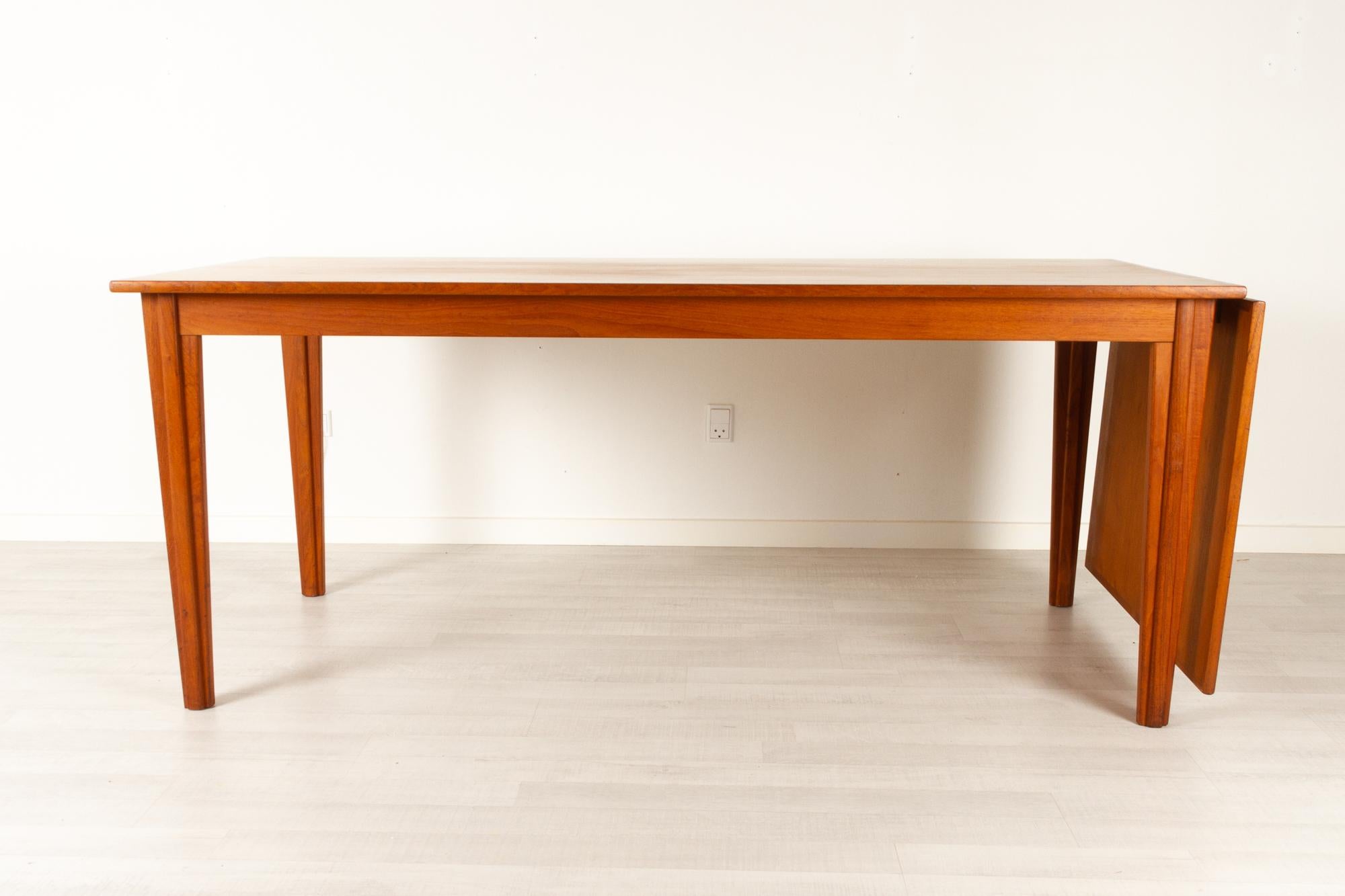 Danish modern teak drop leaf dining table, 1960s
Large dining table with drop leaf extension. Extension leaf can hang on one end or be stored under the table top. Table top slides very easily and can be operated by one person with ease. Tapered
