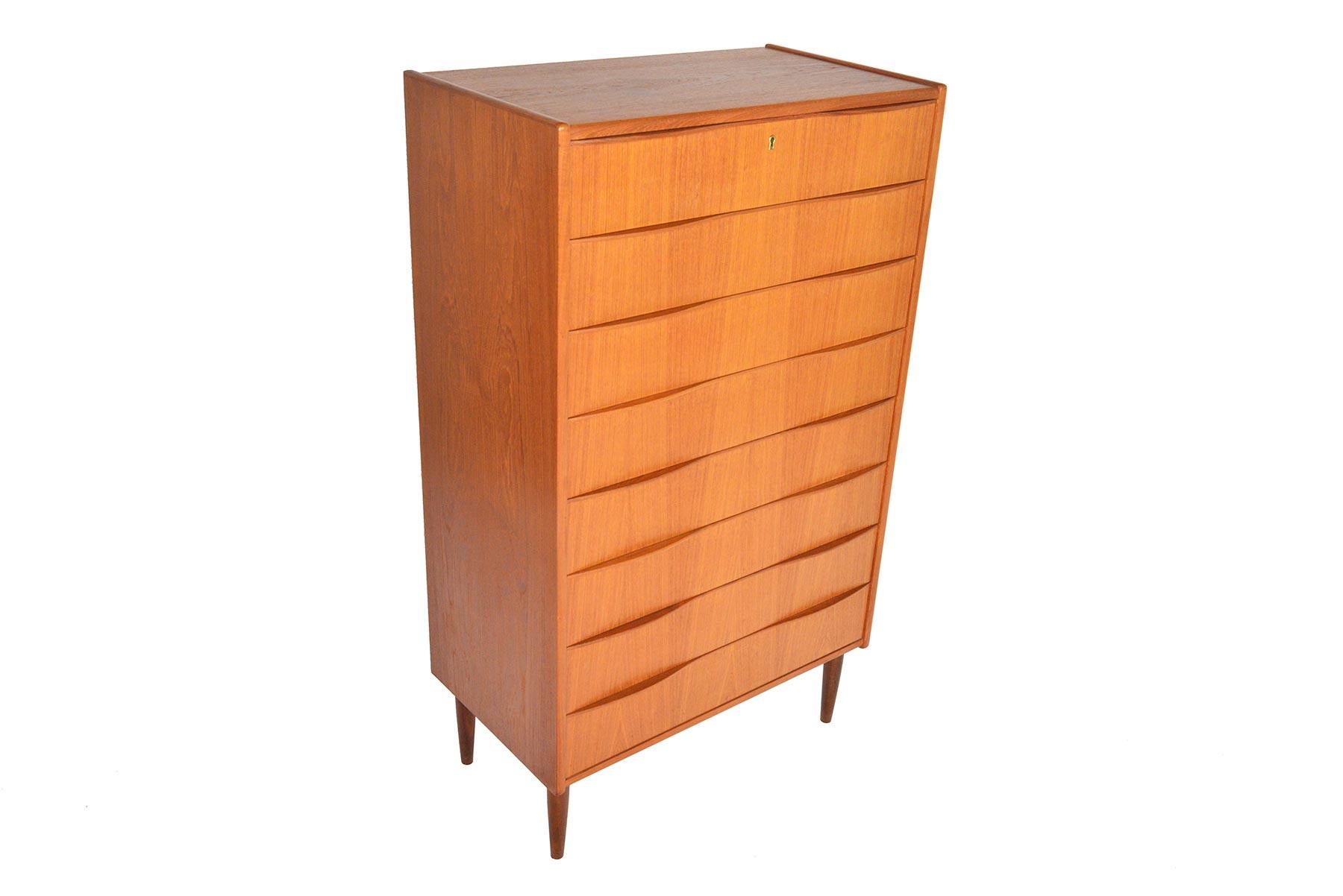 This wonderful Danish modern teak highboy dresser offers deep drawers. Eight drawers are beautifully adorned with sculpted wave pulls for a clean, modern silhouette. In excellent original condition. 

  