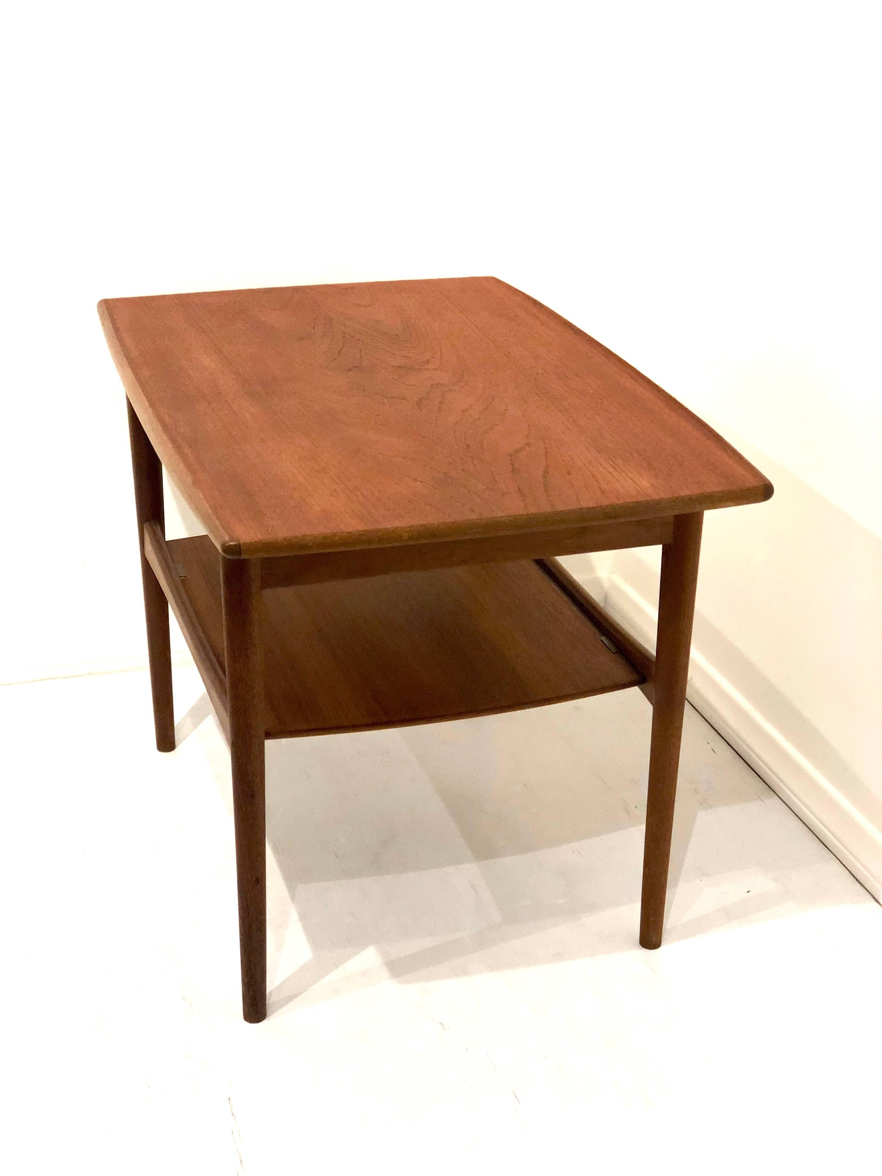 Beautiful simple and elegant end cocktail table by Moreddi in teak with raised edge and shelf nice clean condition no chips or scratches. Stamped at the bottom with Danish Control tag high end and craftsmanship.