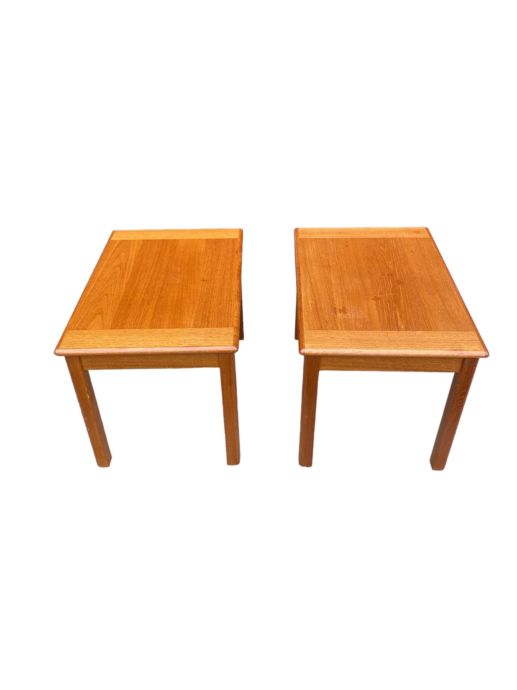 Pair of Danish modern teak end tables / bedside tables. Made by Domino Mobler of Denmark, these vintage tables have even grain and warm teak wood color. Sleek and minimal design. 