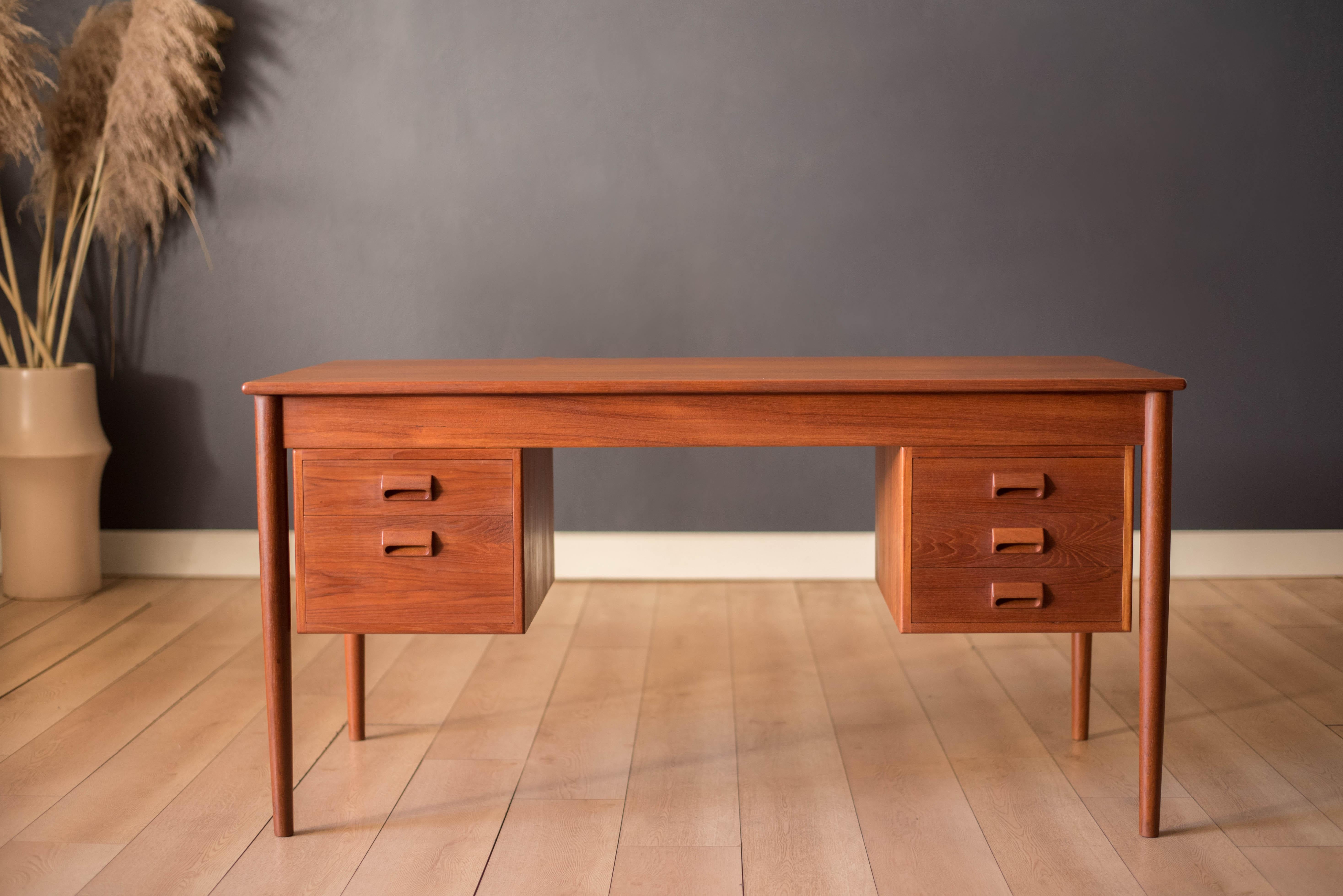 Scrivania direzionale Mid Century Modern disegnata da Børge Mogensen per Søborg Mobler in teak invecchiato, circa 1950. Questo pezzo unico offre molto spazio per riporre gli oggetti, tra cui cinque cassetti a coda di rondine con maniglie scolpite,