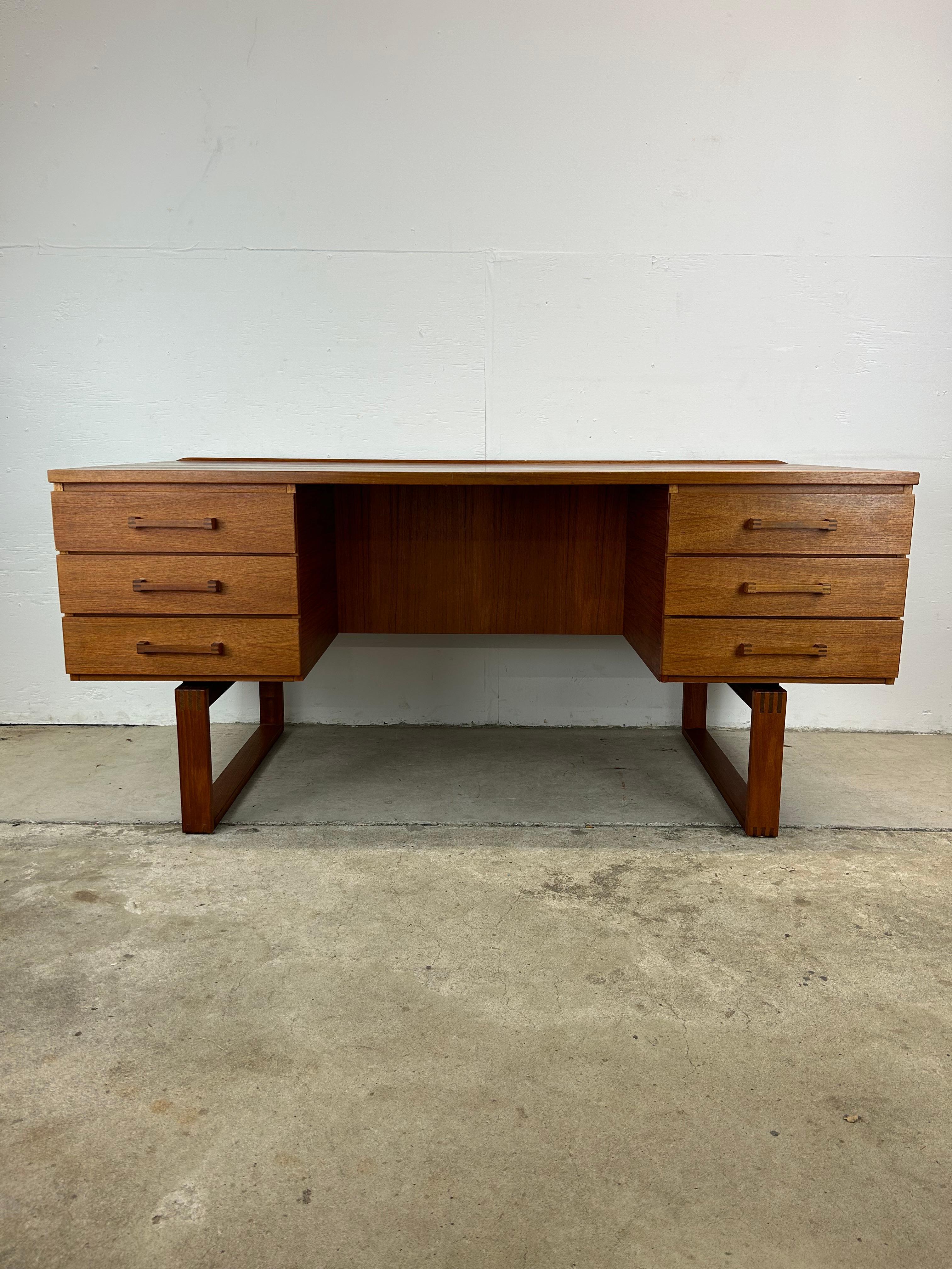 This Danish Modern executive writing desk features teak construction with original finish, six dovetailed drawers with sculpted wood pulls, opened shelving area in the finished back for books, and sled legs.

Please check out our other listings for