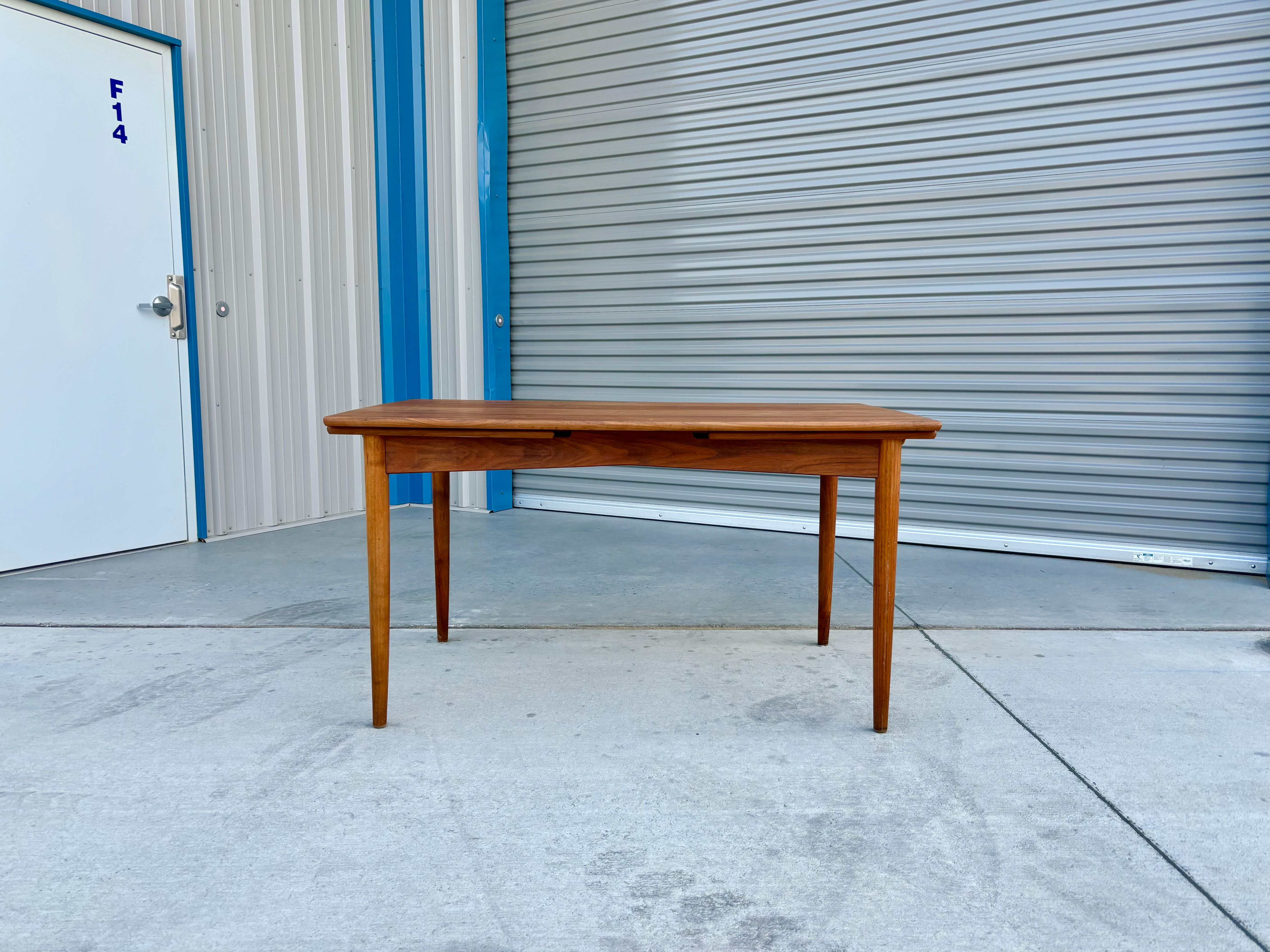 Danish modern extendable teak dining table was designed and manufactured in Denmark 1960s. This exquisite dining table boasts a sturdy and elegant teak frame, which adds a touch of sophistication to any dining space. What sets this table apart is