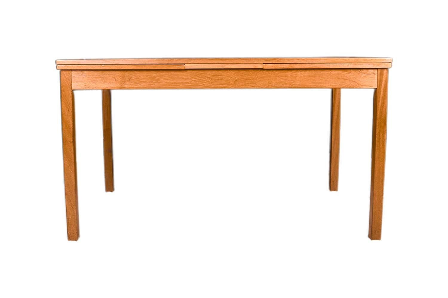 Beautiful, Mid Century Danish Modern draw leaf extendable teak dining table, made in Denmark circa 1960's. With an initial small footprint, this table can also offer a generous space and double in size once its draw leaves are extended. Amazing