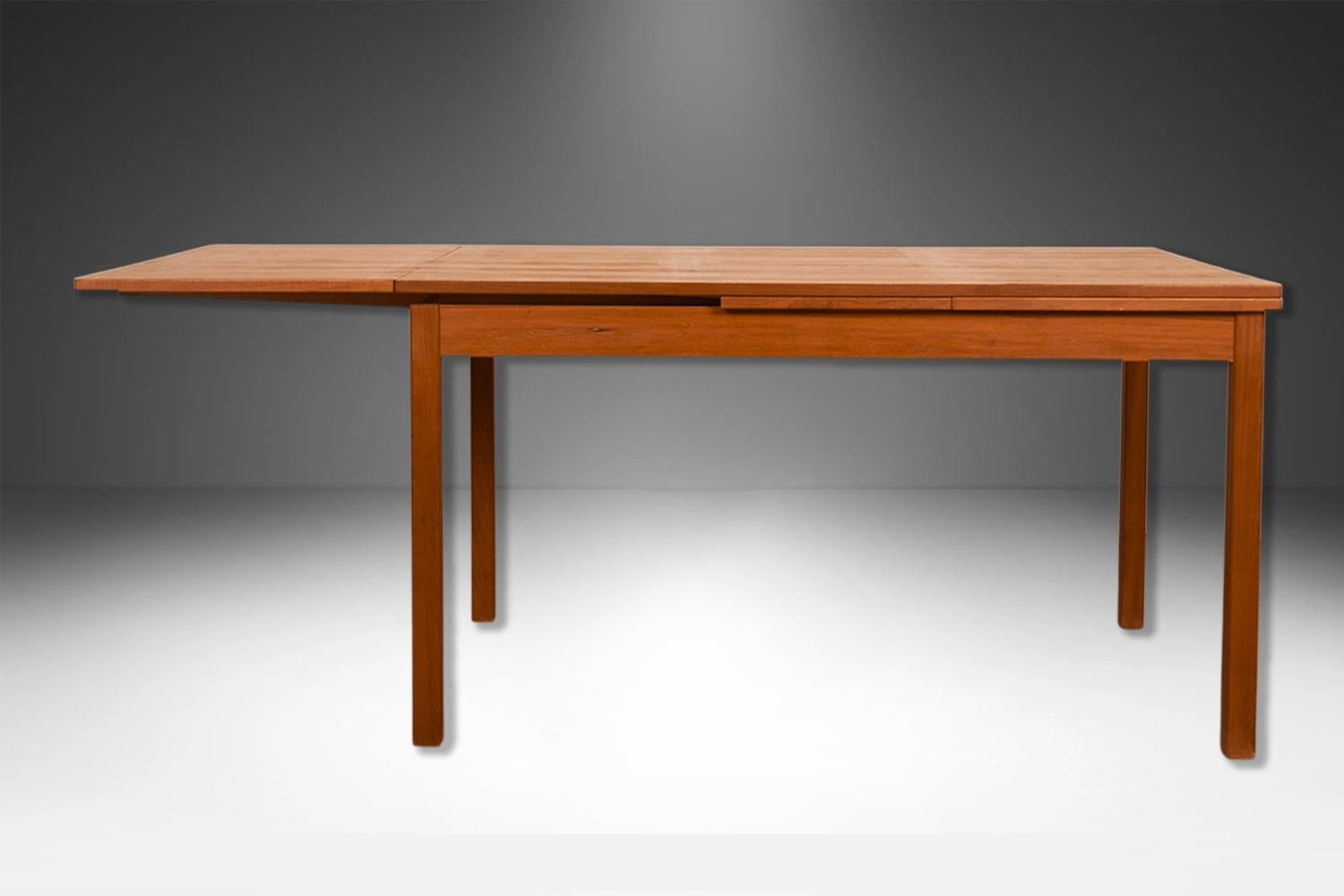 An exceptional, Danish, Modern, teak draw leaf Expandable dining table, by Vejle Stole Møbelfabrik made in Denmark. With an initial large footprint, this table can also offer a generous space and double in size once its hidden draw leaves are