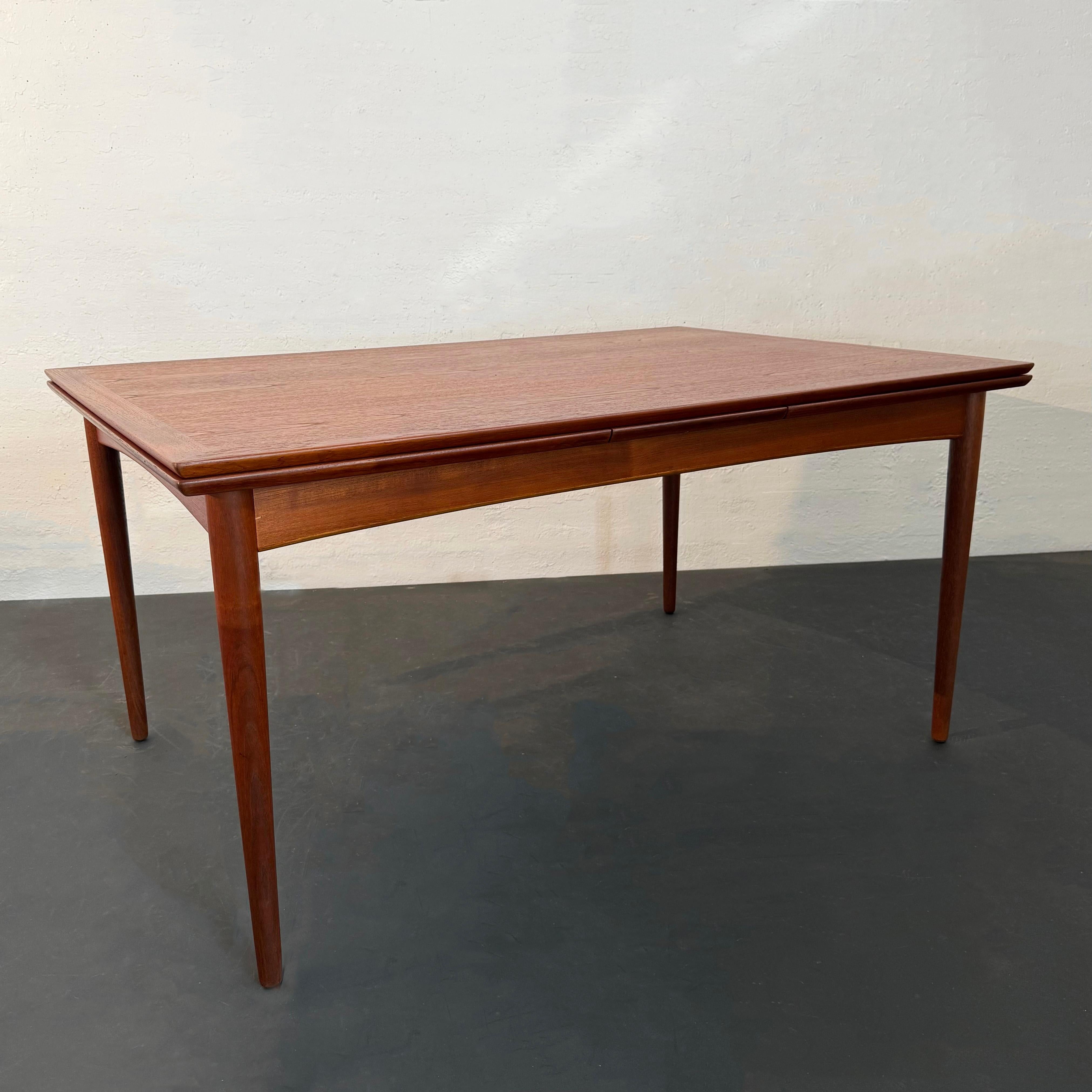 This classic, Scandinavian Modern teak extension dining table, was made in Denmark by premier Danish maker Selig. With an initial small footprint, this table practically doubles in size to 101.5